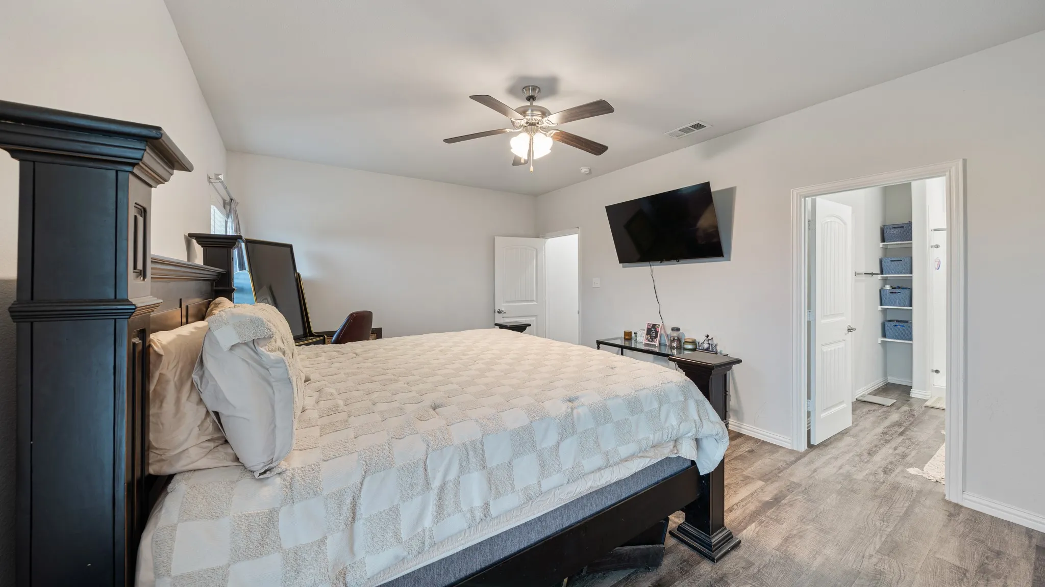 Vaulted ceilings with a ceiling fan, wood-finish flooring, and light-toned walls