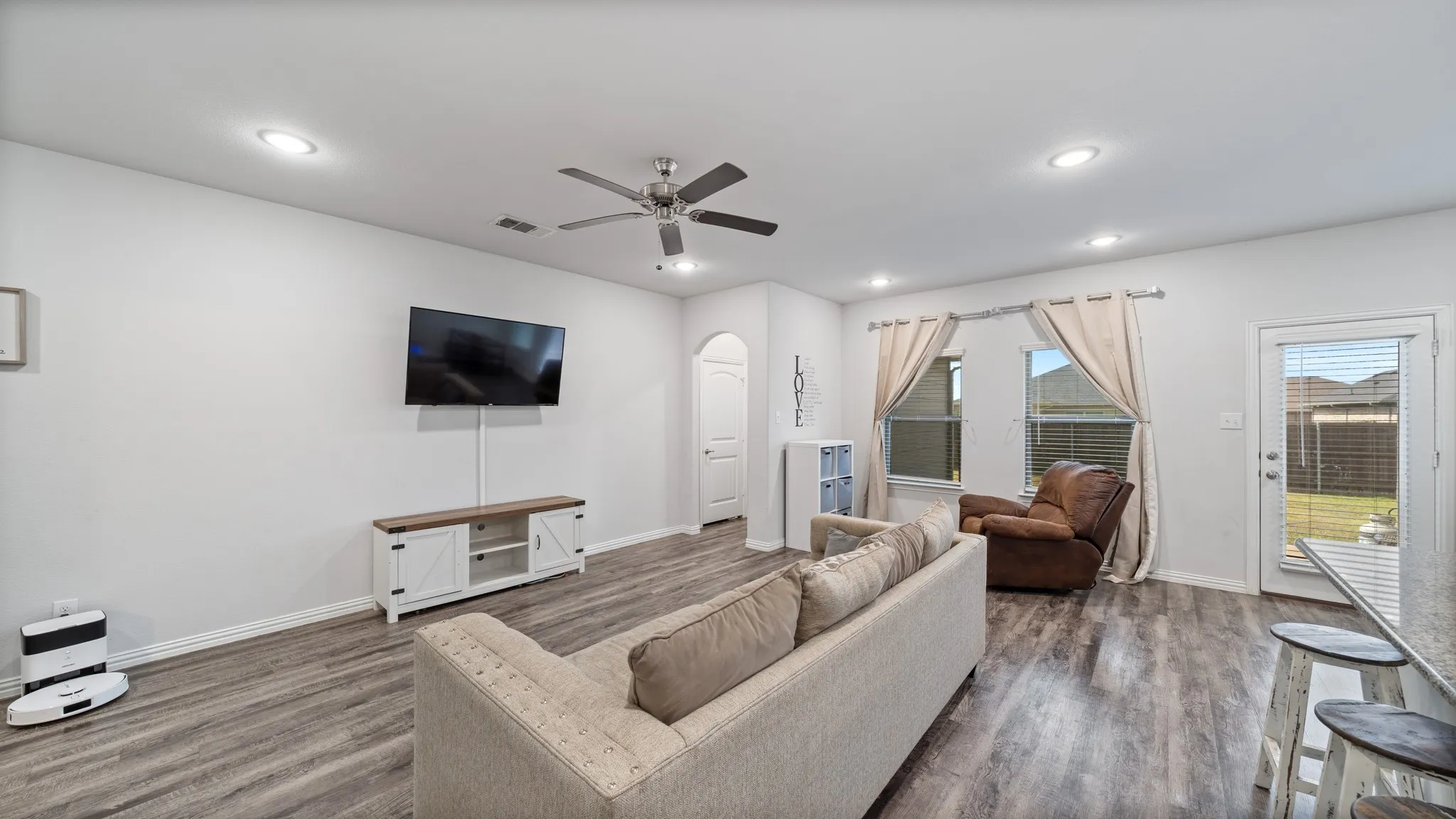 Recessed lighting, wood-finish flooring, ceiling fan, multiple windows, and a rear door