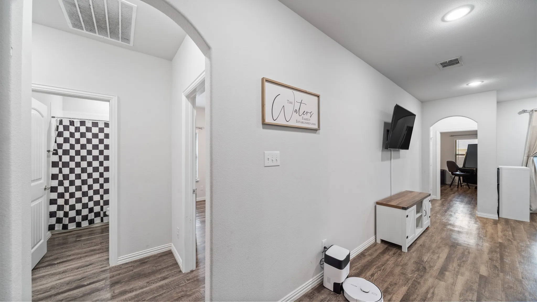 Wood-finish flooring throughout, complemented by arched doorways and recessed lighting