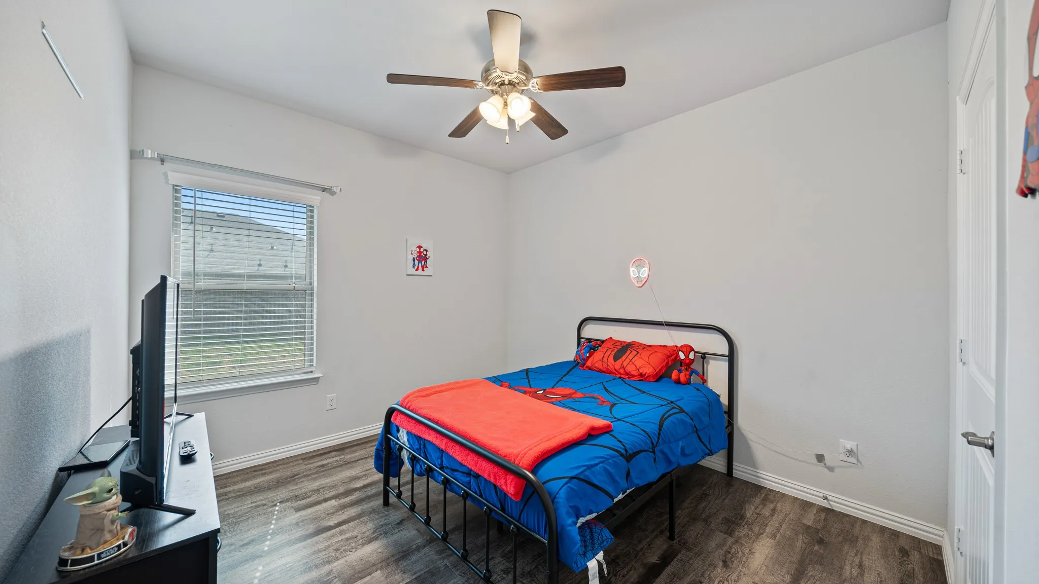Vaulted ceiling with a ceiling fan, wood-finish flooring, and a window with blinds