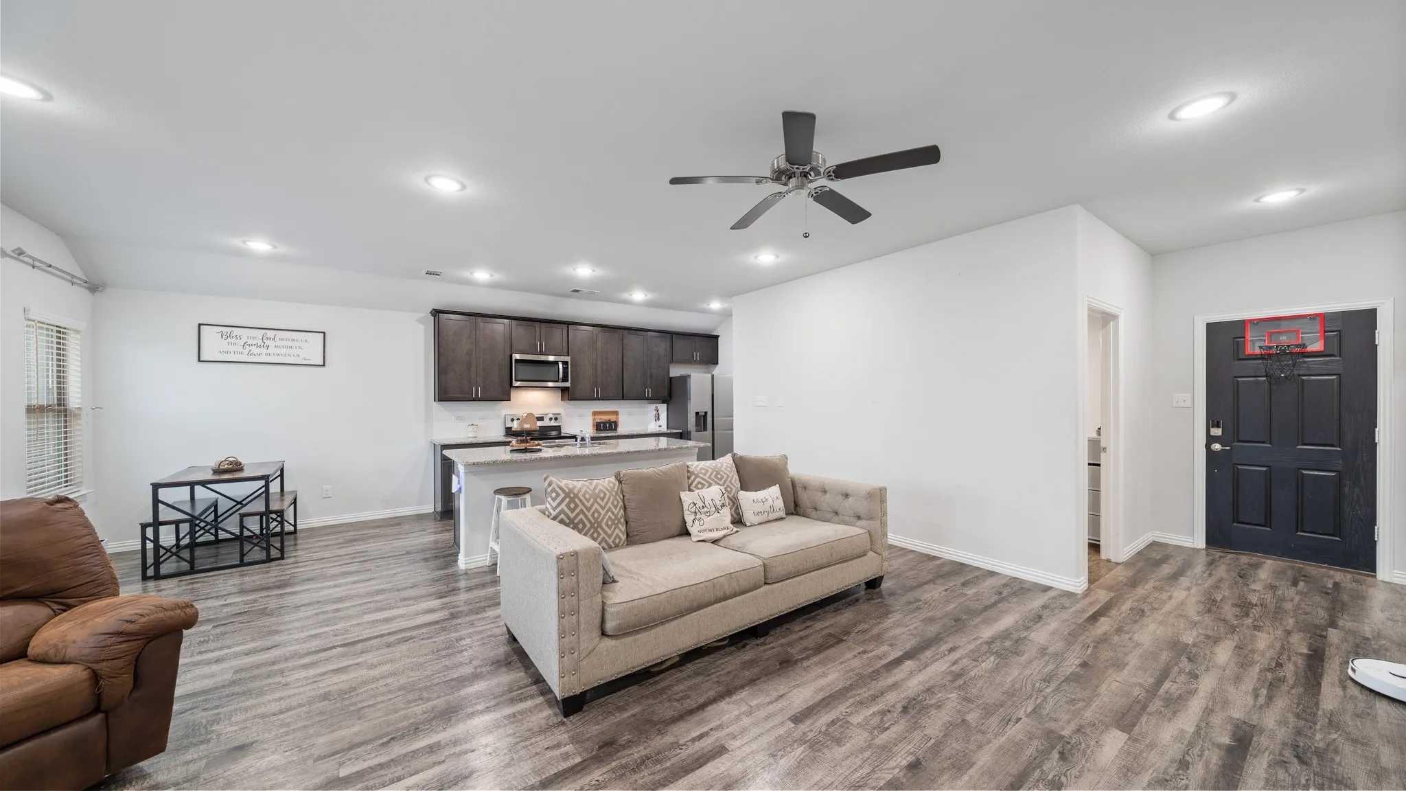 Open-concept living area featuring wood-finish flooring, recessed lighting, and a ceiling fan