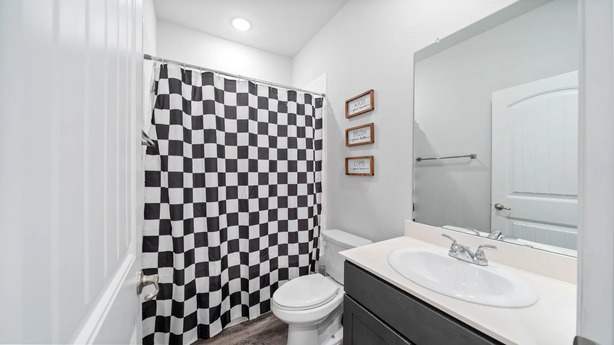 Recessed lighting, single vanity with light-colored countertop, and a built-in mirror