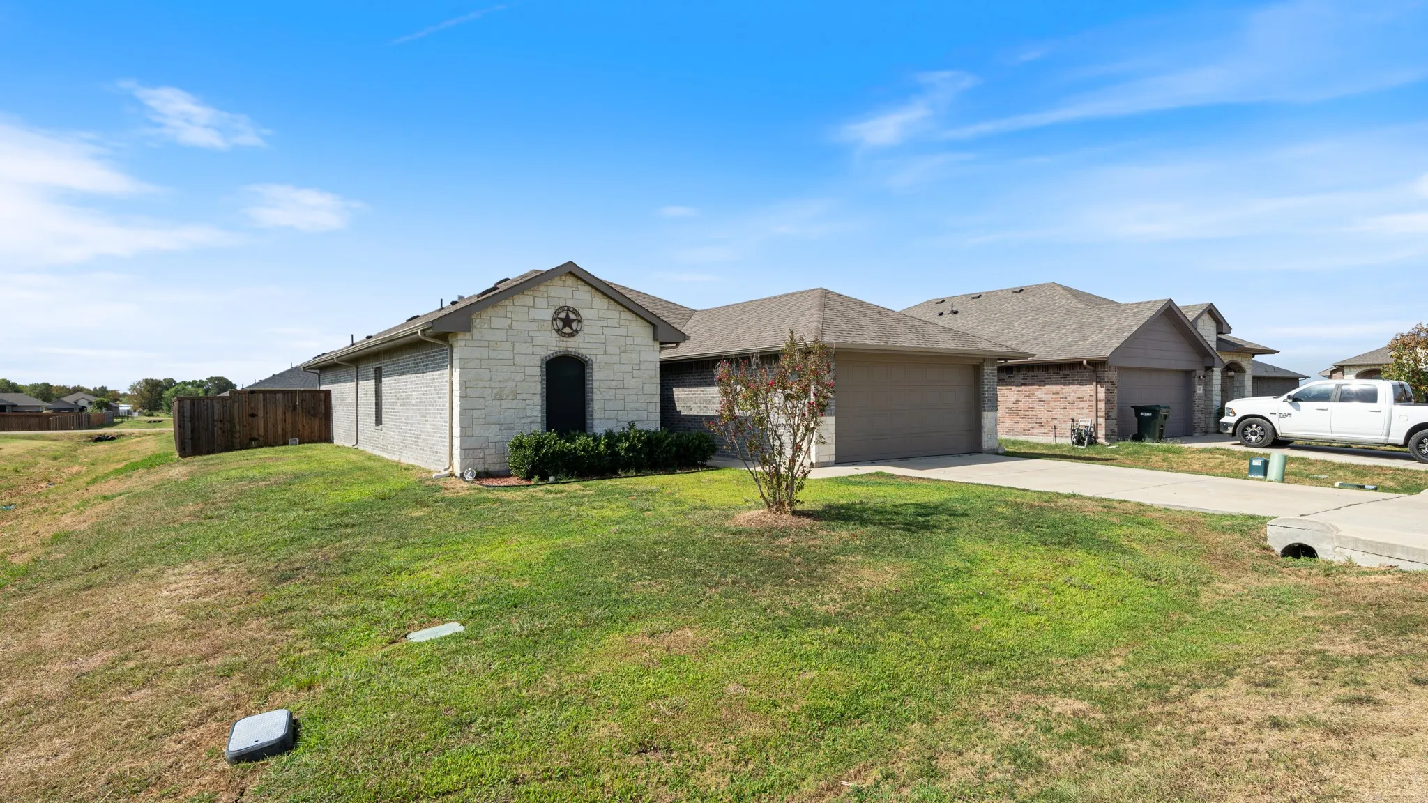 Single-story residence featuring a stone and stucco exterior, an attached garage, and a concrete driveway