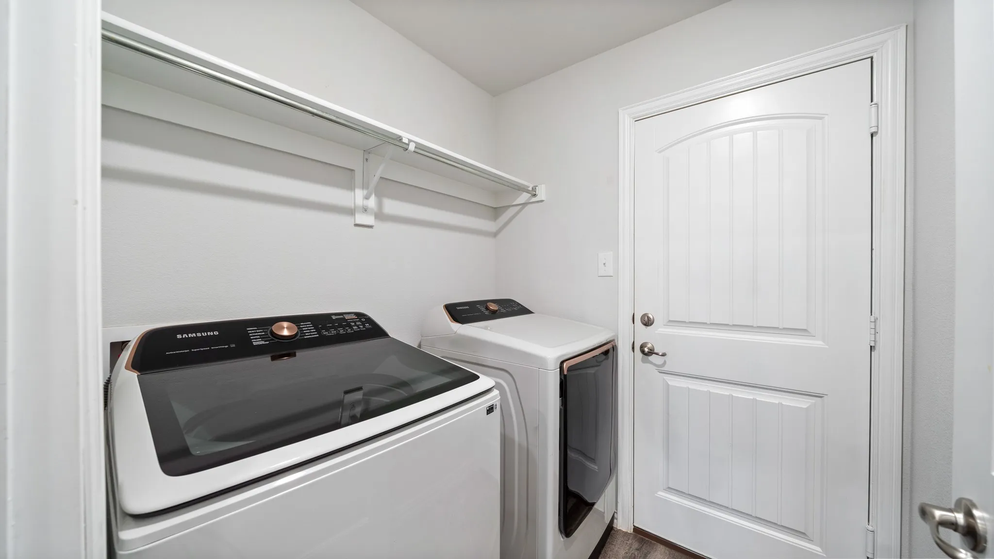 Laundry area with white walls and a white paneled door