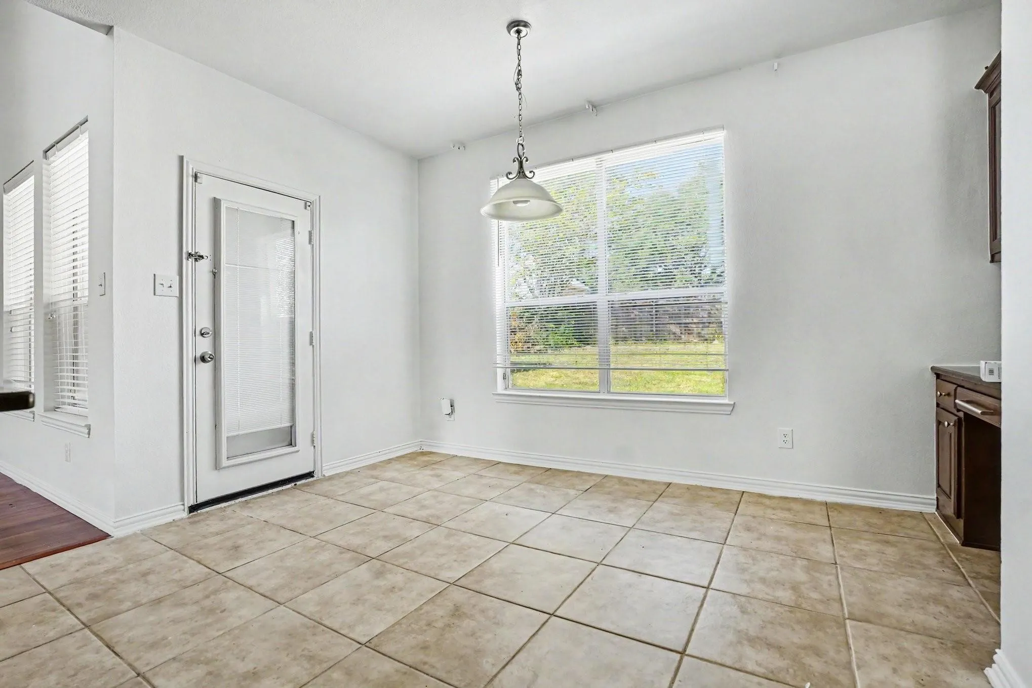 Ceramic tile flooring, white walls, and a glass-paneled door