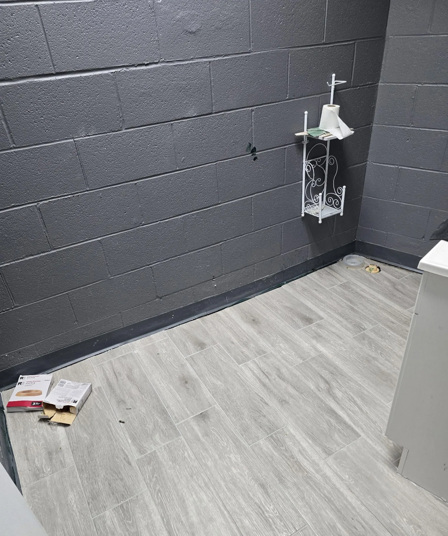 Gray wood-look plank flooring complements the dark gray block wall construction