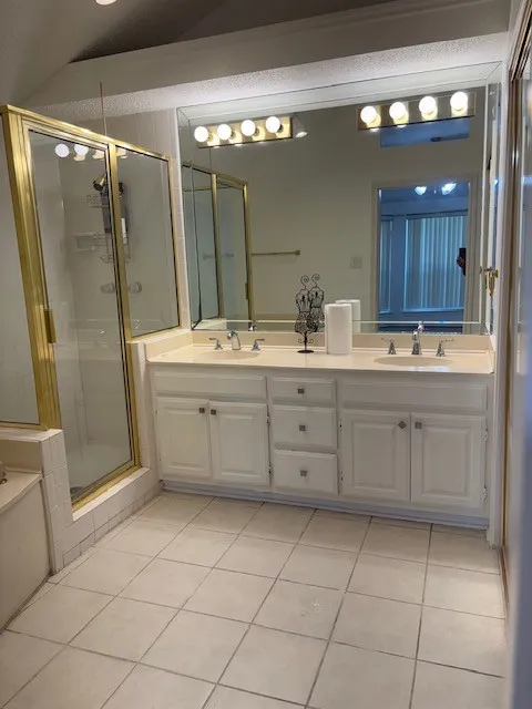 Dual vanity with undermount sinks, large wall-mounted mirror, and overhead lighting