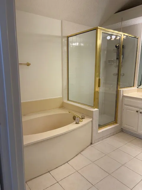 Built-in soaking tub, glass-enclosed shower, and tiled flooring