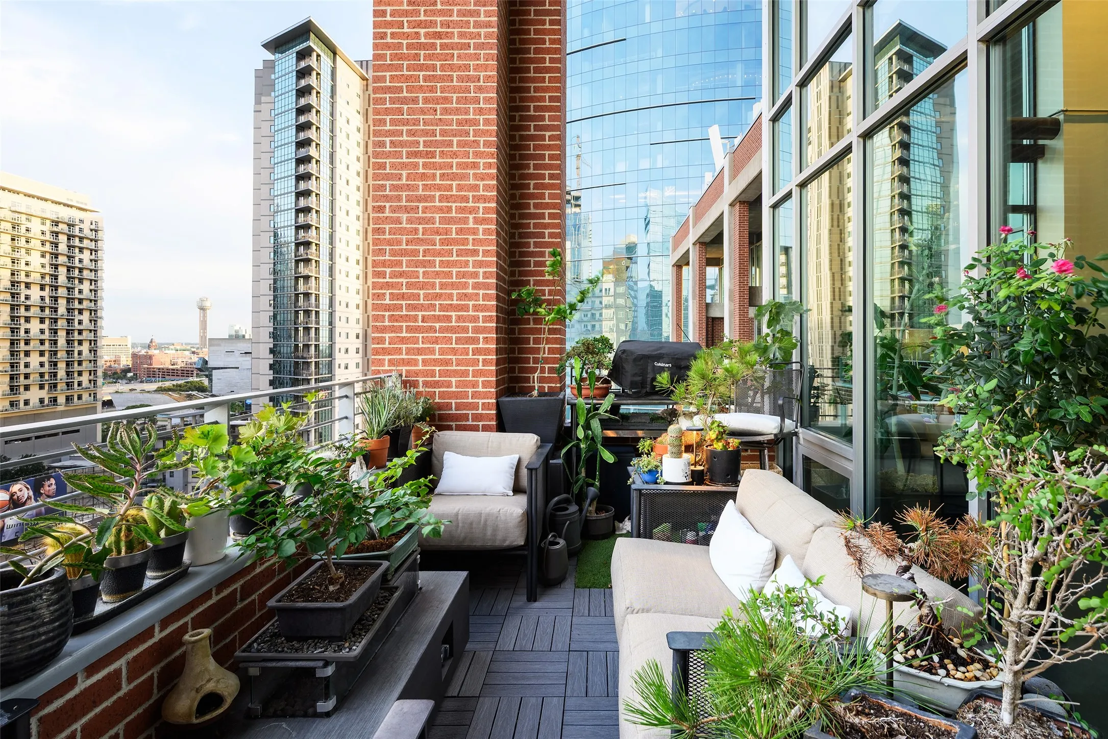 Balcony featuring brick walls, horizontal railing, and plank flooring
