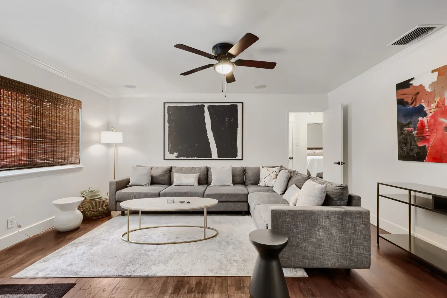 Wood-finish flooring, crown molding, and a ceiling fan with integrated lighting