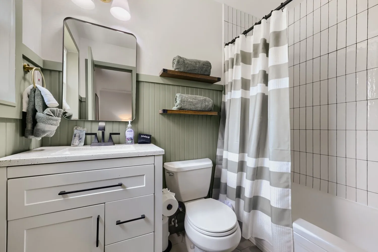 Modern vanity with a light-toned countertop, black faucet, and rectangular mirror