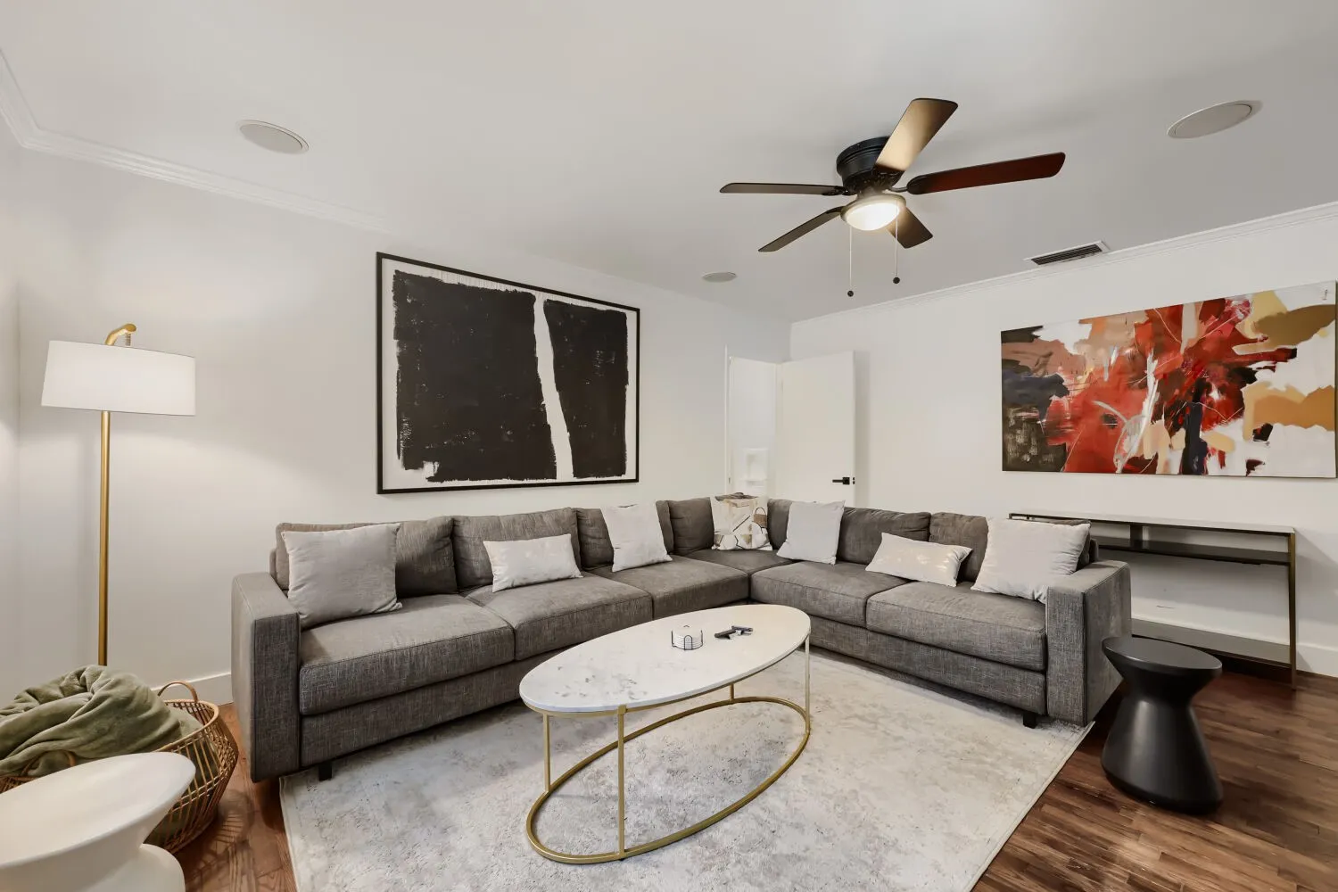 Dark wood-finish flooring, white crown molding, and a ceiling fan with integrated lighting