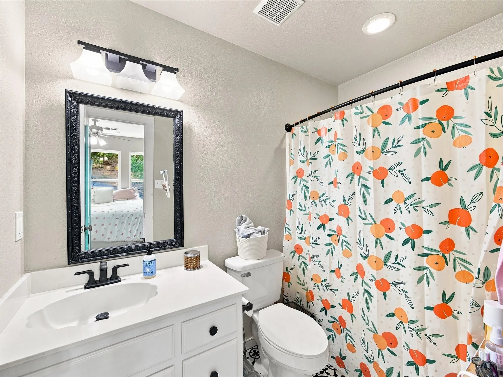 White vanity with integrated sink, black framed mirror, and matte black faucet