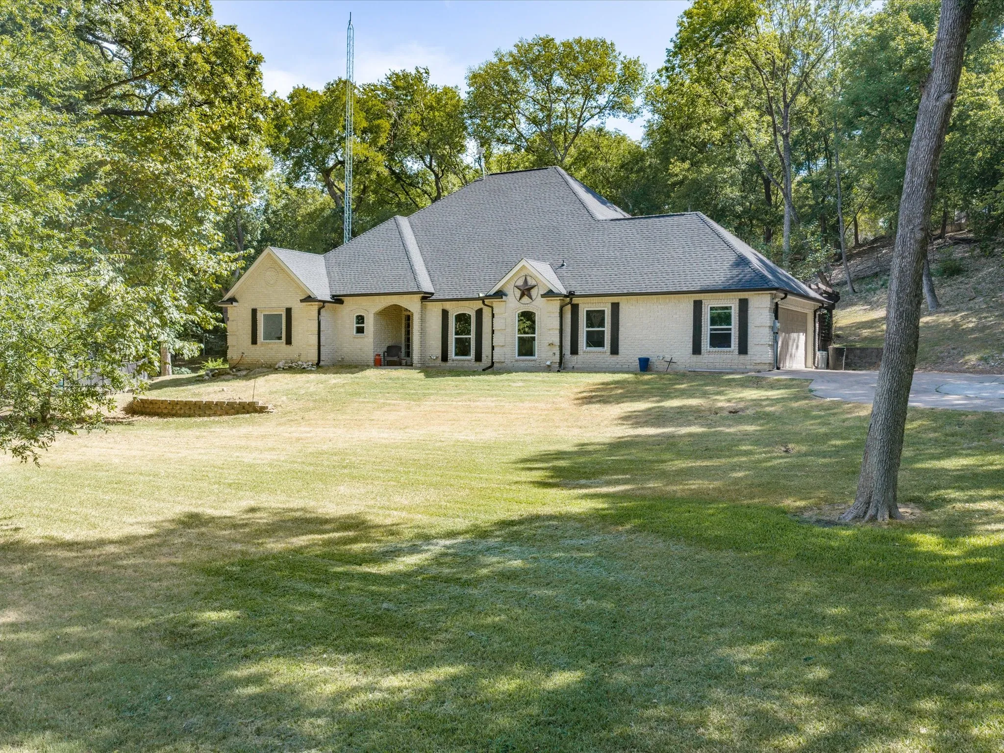 Single-story residence featuring a light-colored brick exterior, dark-toned roof, and a covered front entry