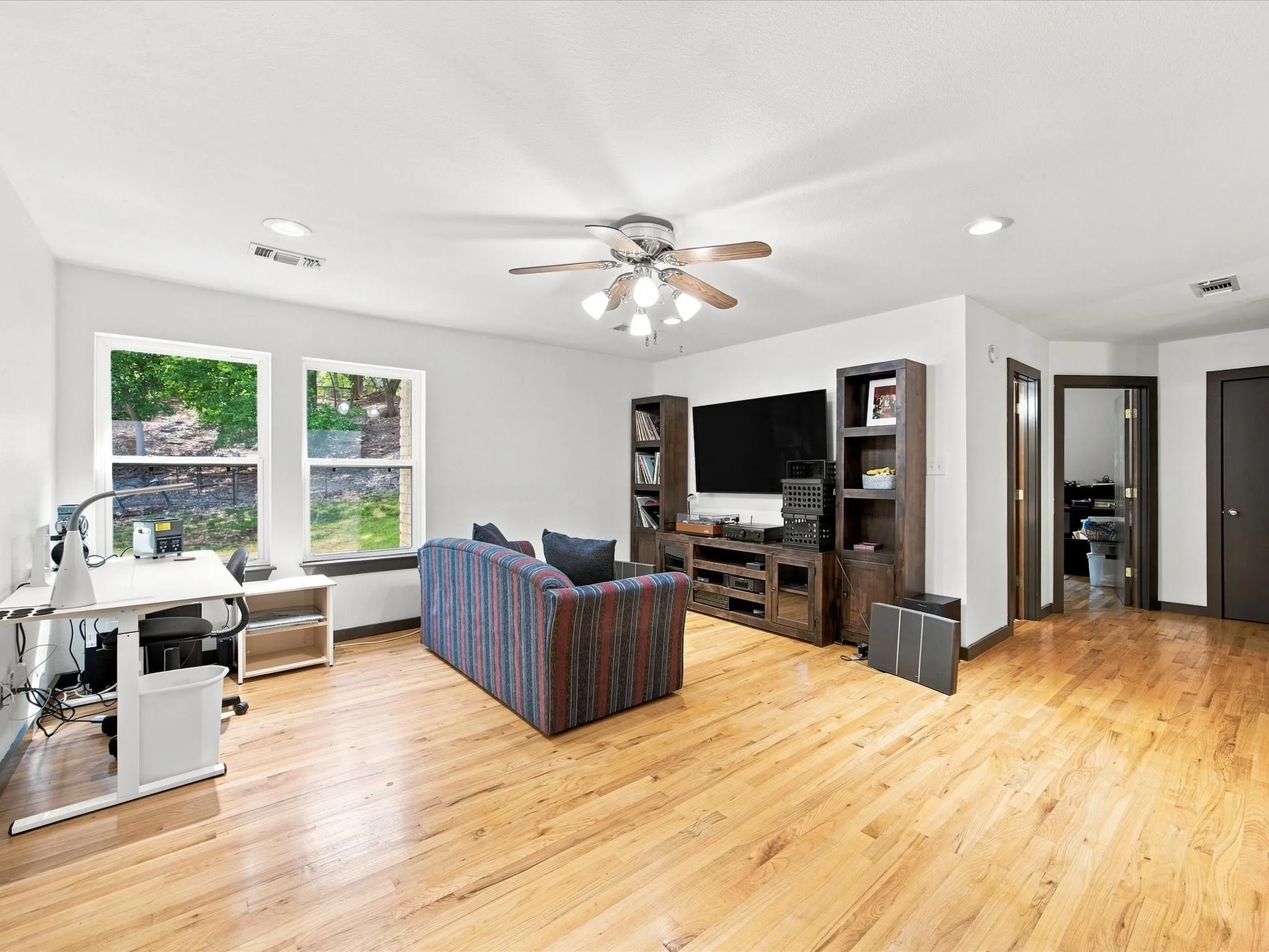 Hardwood flooring, recessed lighting, ceiling fan, and multiple windows