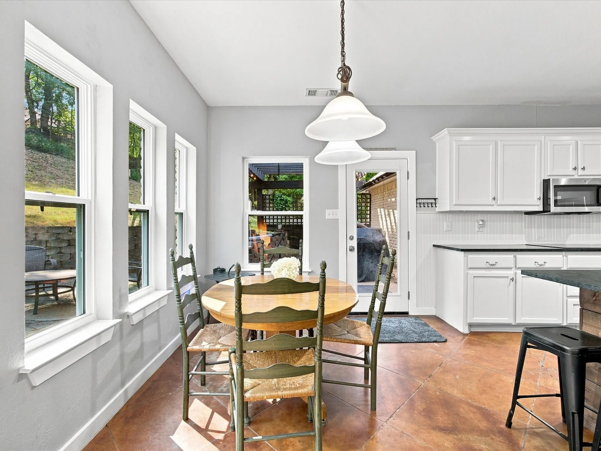 Kitchen area with white cabinetry and dark countertops