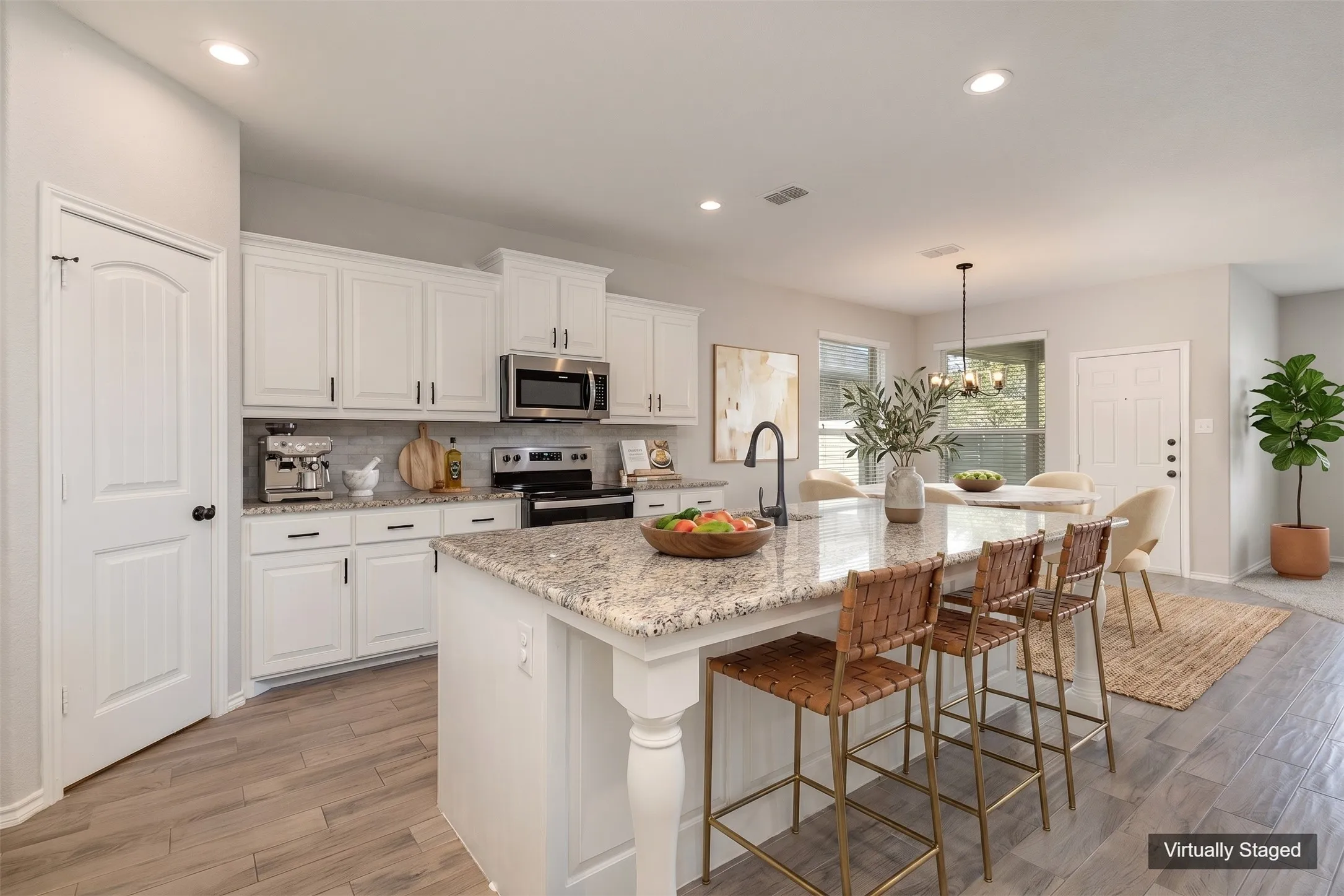 Virtually Staged View of kitchen and dining area. Large kitchen island with designated sitting area, sink, granite countertops.