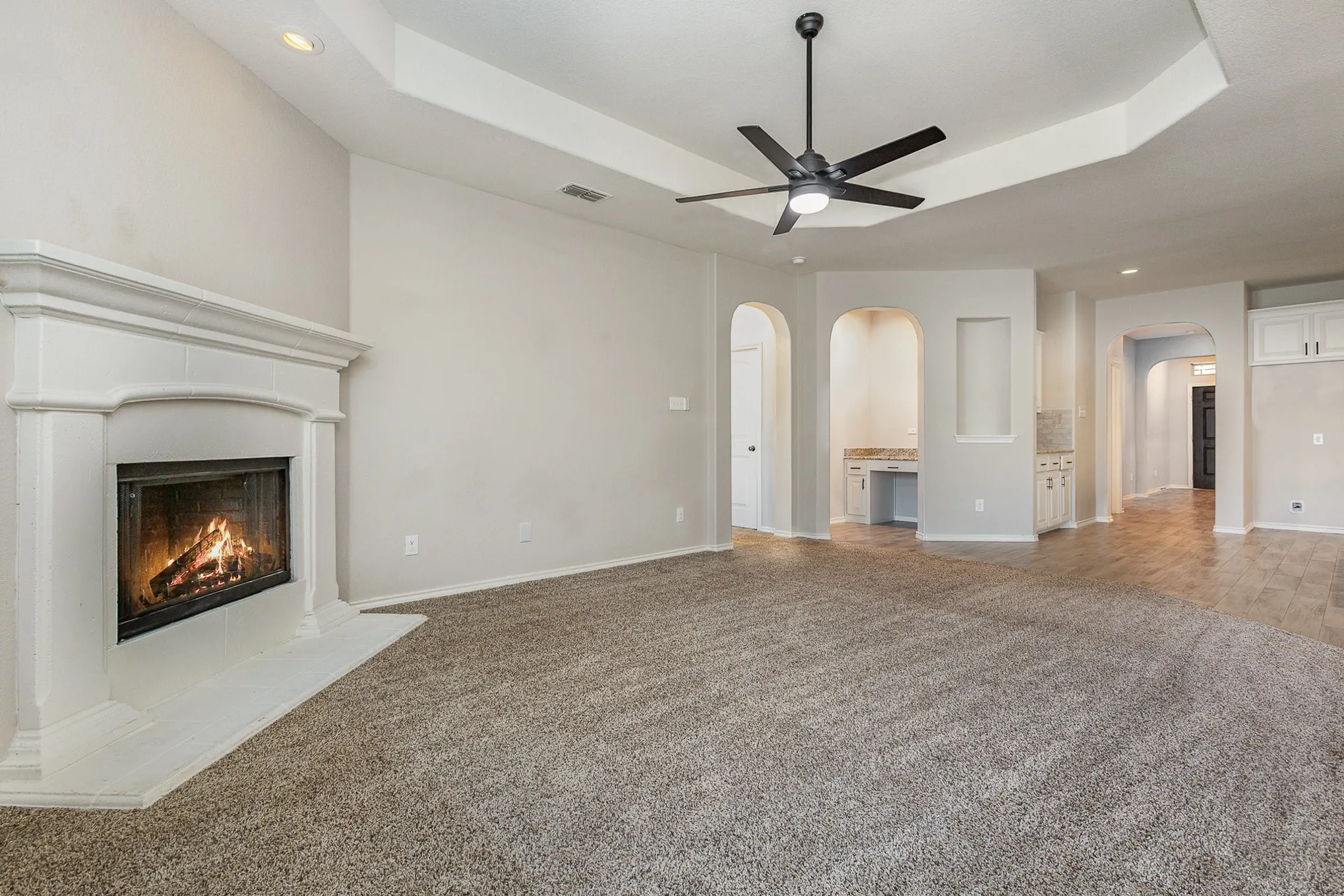 Great room view of living room with built-in desk area, and kitchen's dry bar that may be used as coffee station.