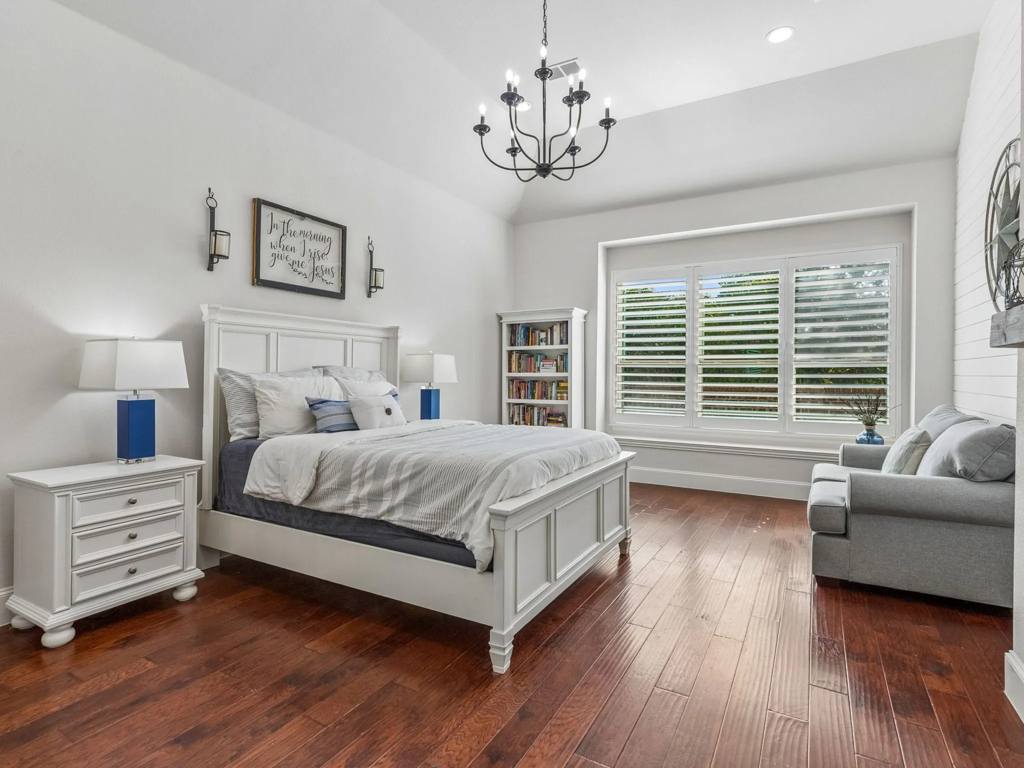 Vaulted ceiling, engineered hardwood-finish, plantation shutters, built-in window bench, and a decorative chandelier.
