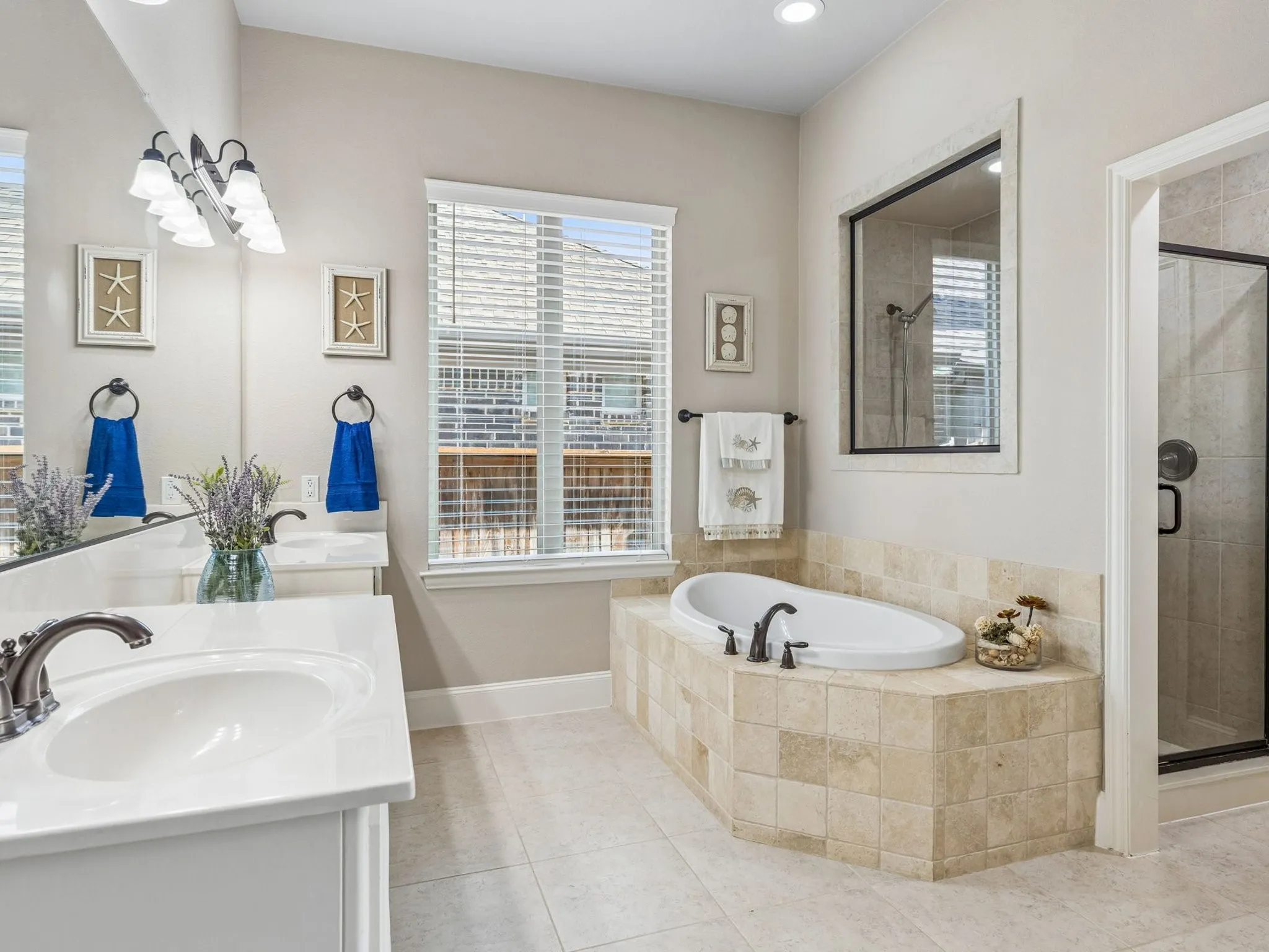 Dual vanity with undermount sinks, bronze finish faucets, and walk in shower.