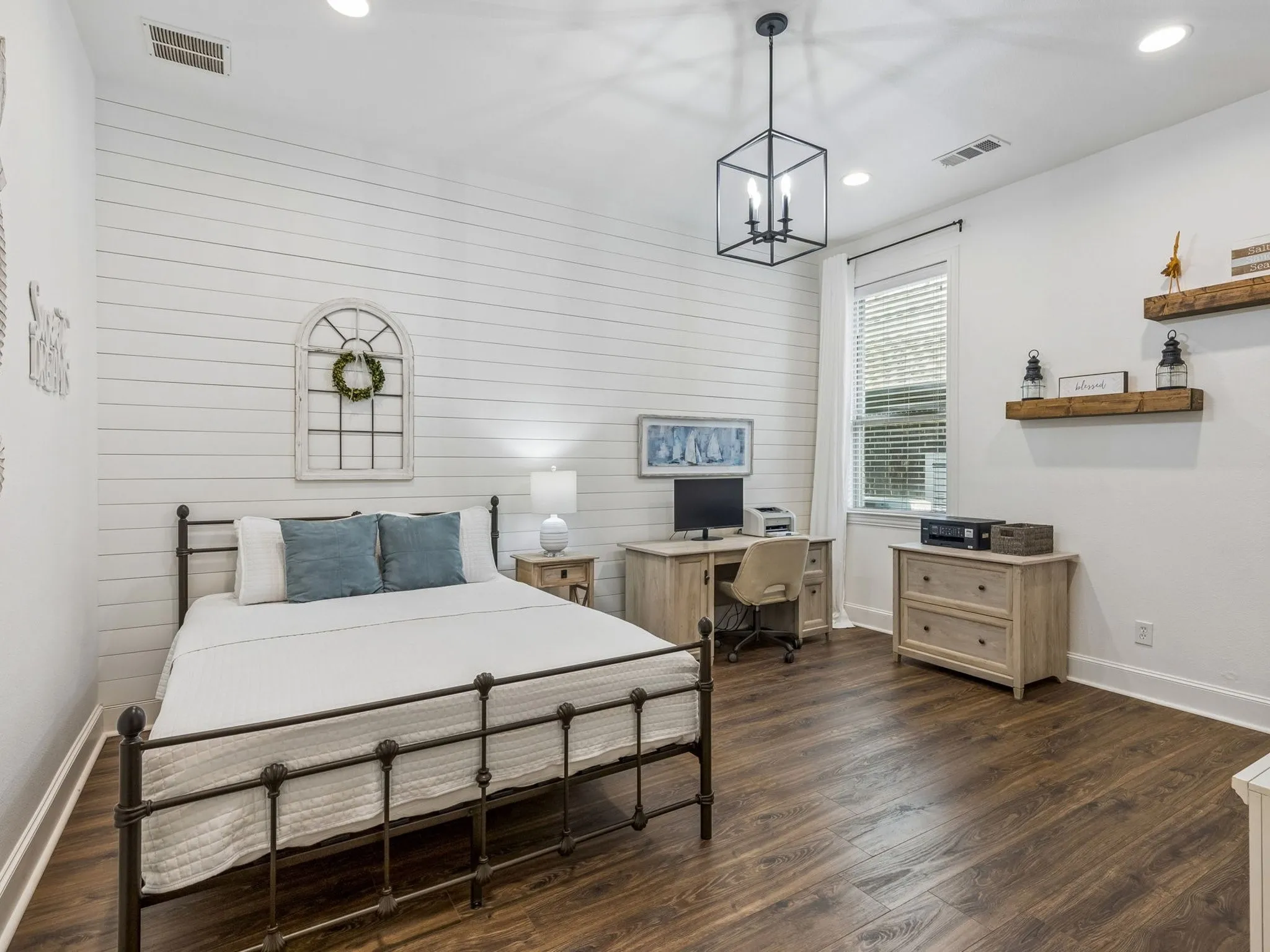 Wood-finish flooring, white shiplap accent wall, recessed lighting, a modern black chandelier, and a window with blinds