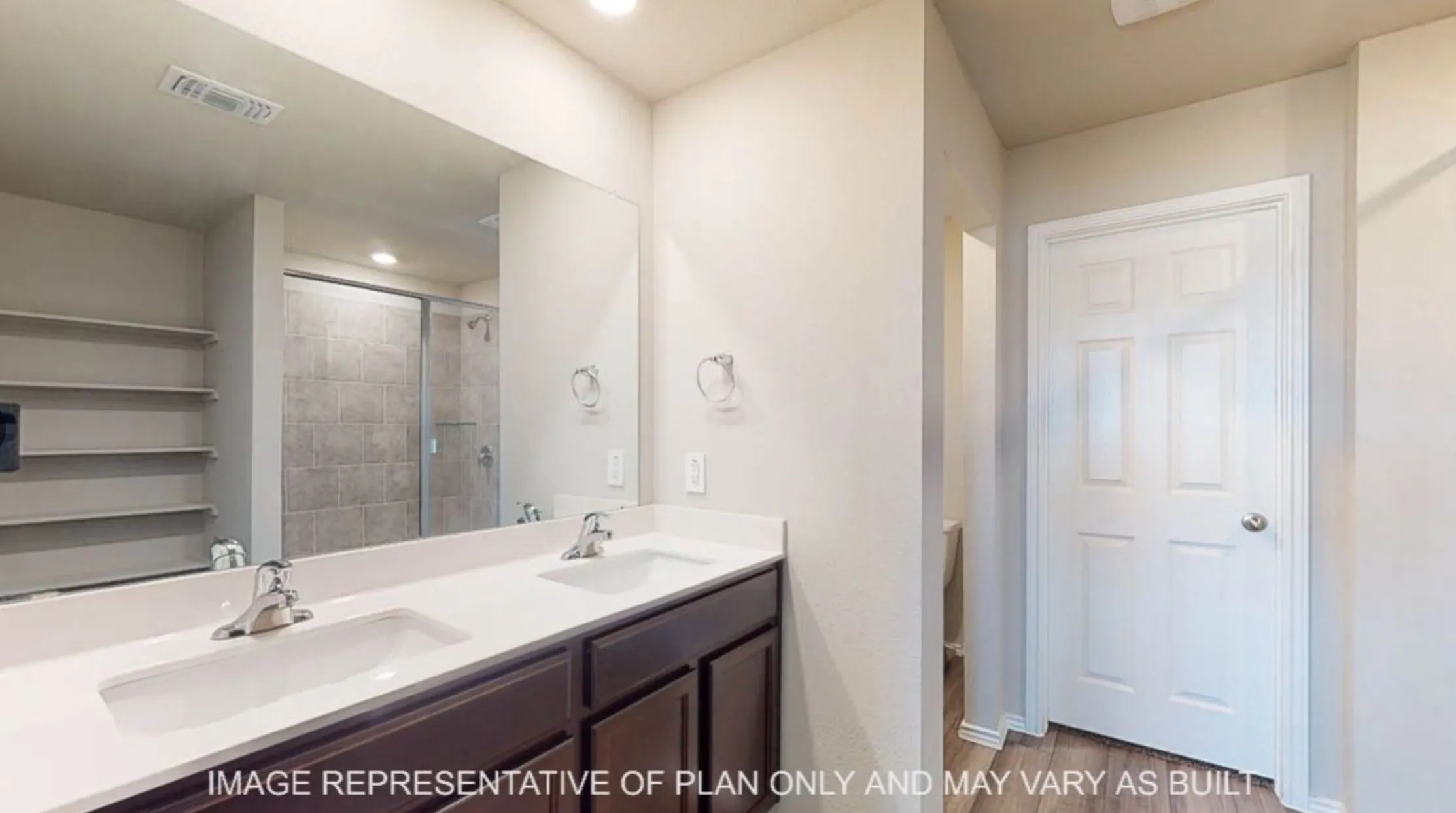 Dual vanity with integrated sinks, dark wood-finish cabinetry, and a large wall-mounted mirror