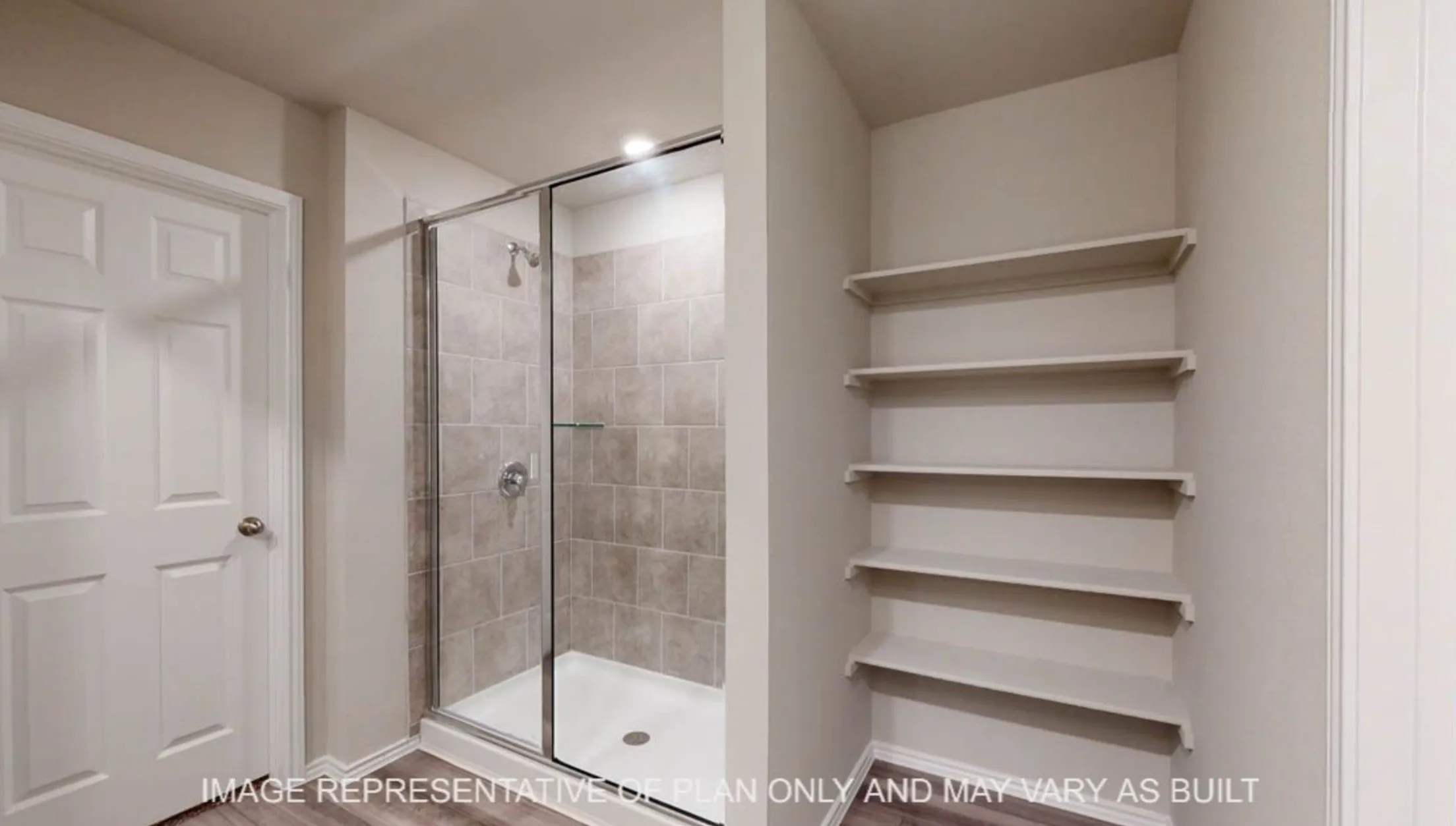 Glass-enclosed shower with tiled walls and a built-in shower niche, accompanied by extensive built-in shelving
