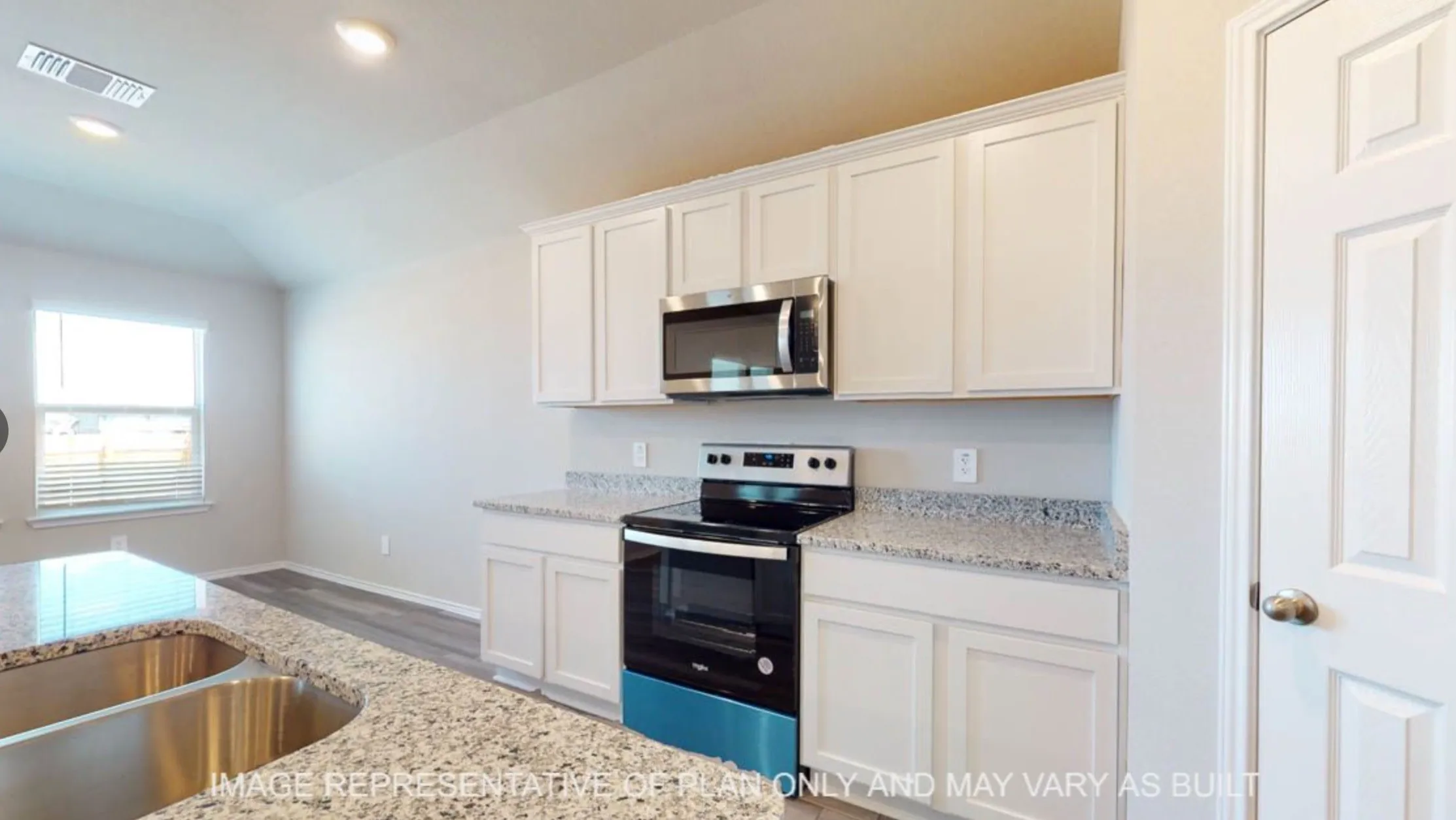Kitchen featuring white shaker-style cabinetry, stainless steel appliances, speckled countertops, and a double basin sink