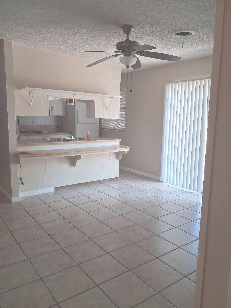 TILED FLOORING AND SLIDING DOORS OUT TO FENCED BACKYARD