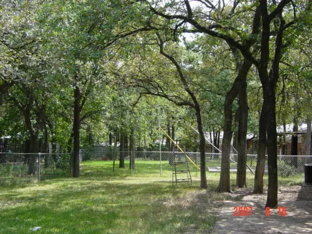 PATIO AND STORAGE SHED IN THE FENCED BACKYARD.