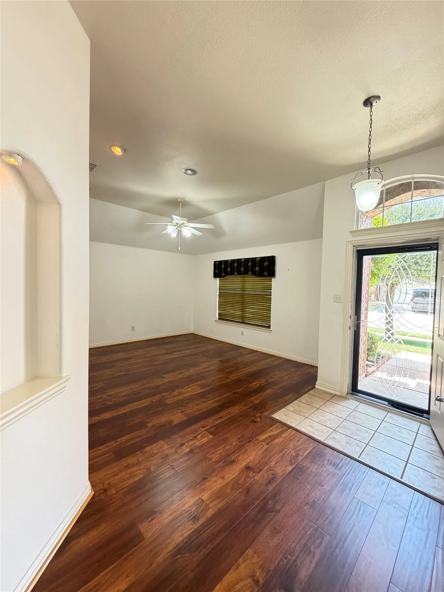 Vaulted ceiling with a ceiling fan, recessed lighting, wood-finish flooring, and a tiled entryway