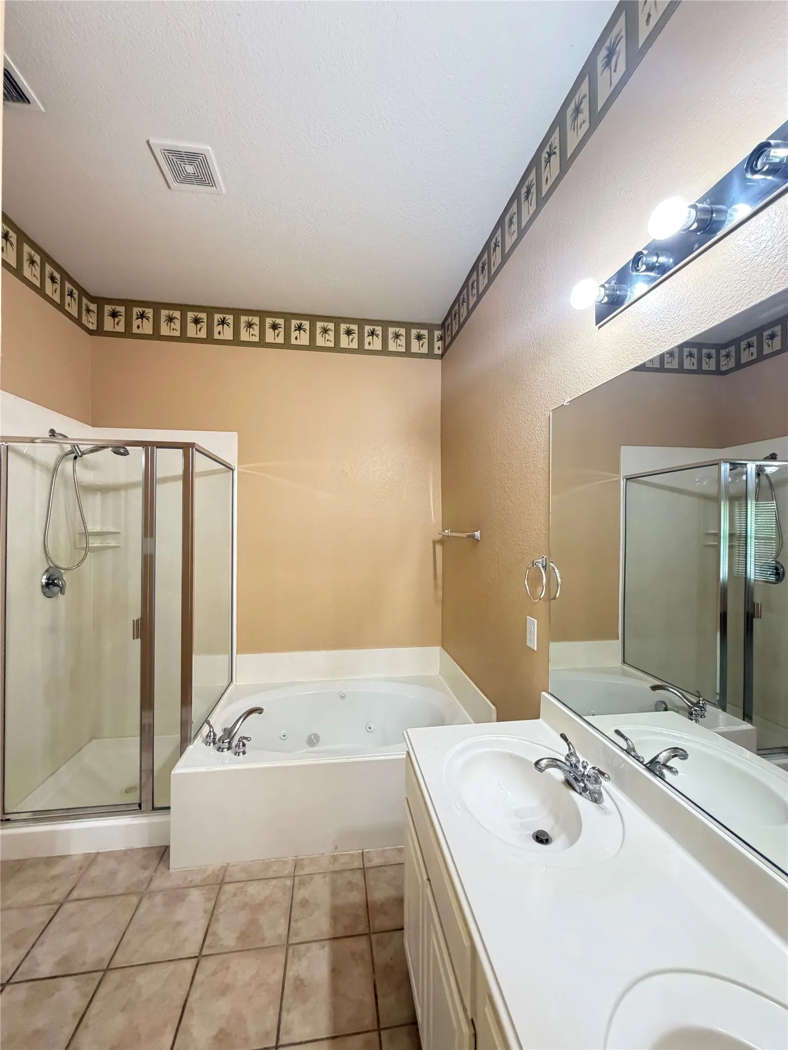 Dual vanity with integrated sinks, a jetted soaking tub, and a separate glass-enclosed shower