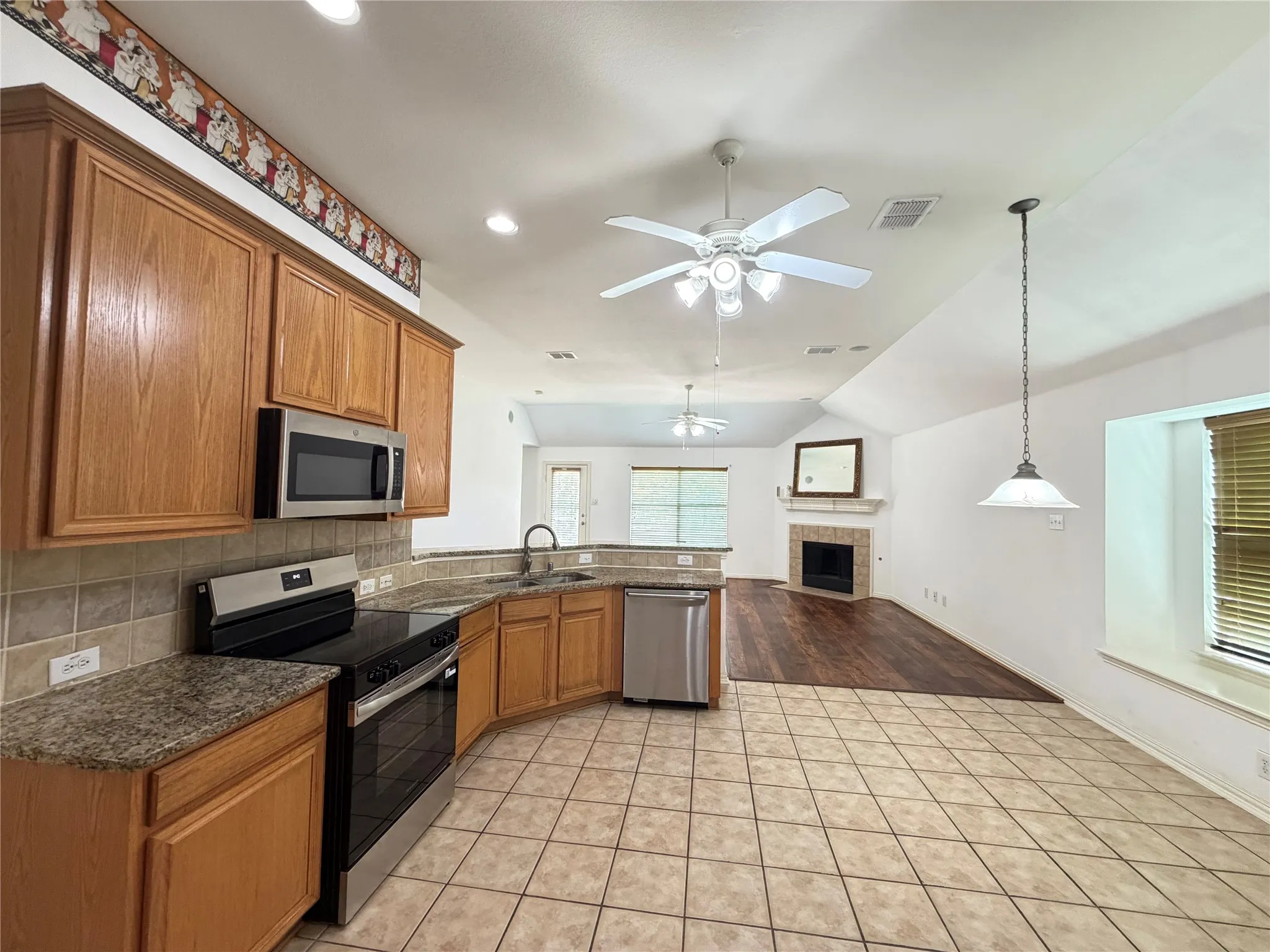Kitchen featuring wood cabinetry, stainless steel appliances, and tile flooring