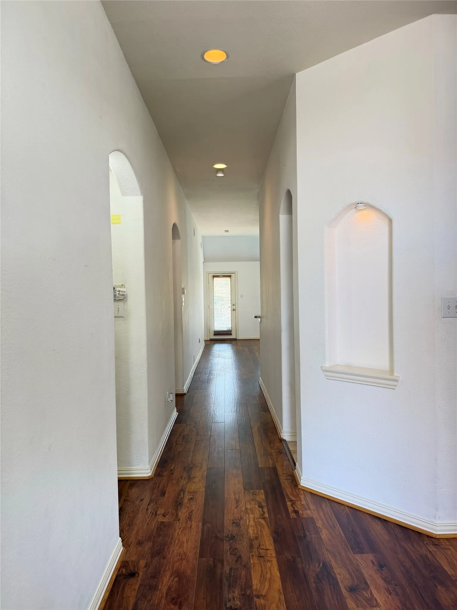Wood-finish flooring throughout, recessed lighting, and arched wall niches
