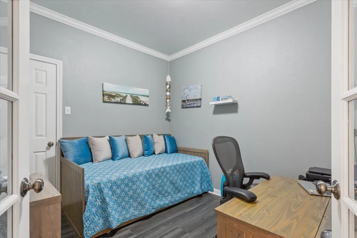 French doors with glass panels, crown molding, gray wall paint, and wood-finish flooring