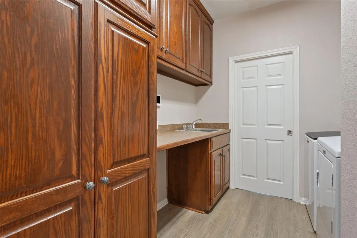 Built-in wood-finish cabinetry, countertop, and sink basin with chrome faucet