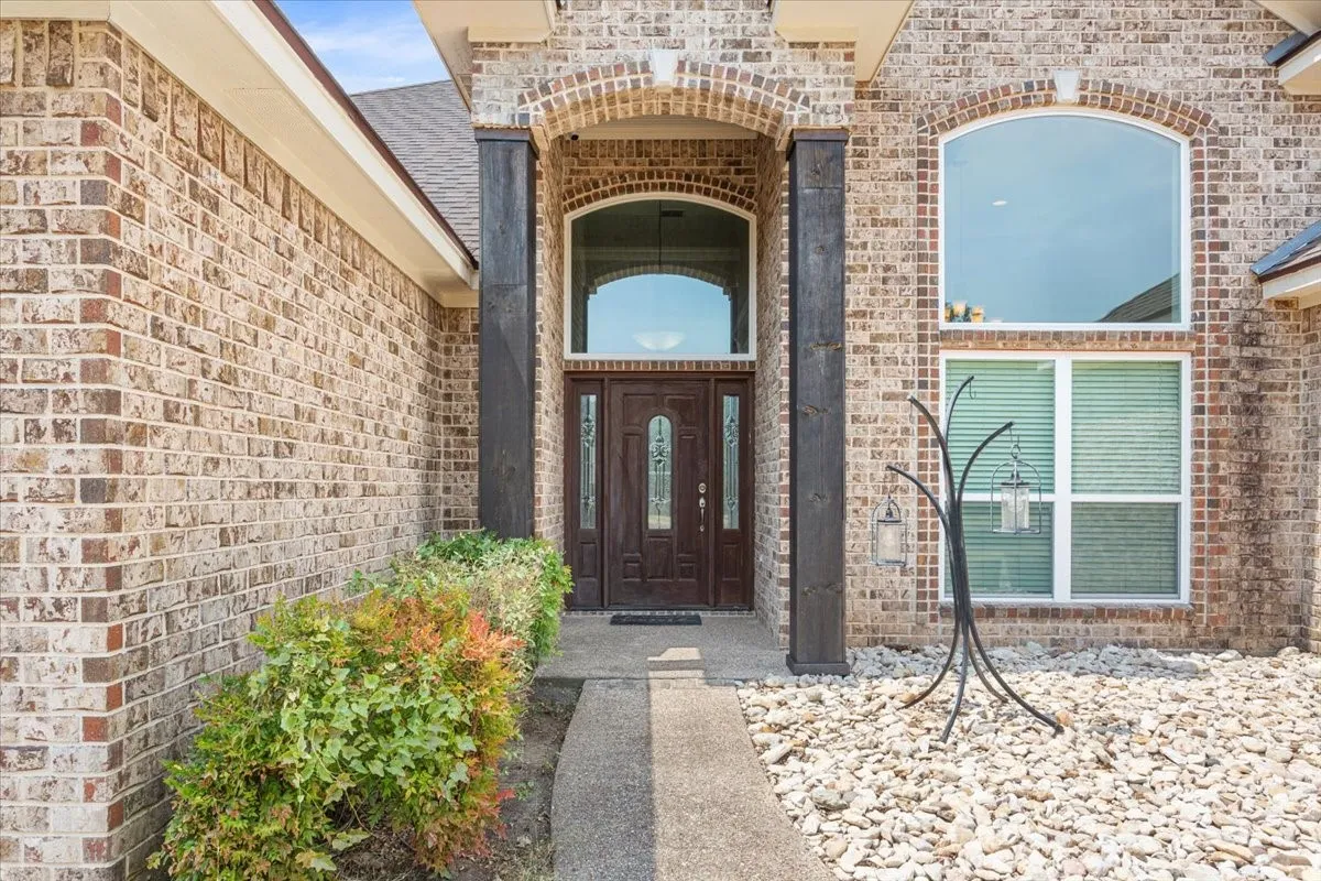 Brick exterior with an arched entry and wood-finish columns