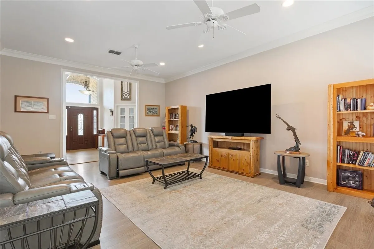 Hardwood flooring in the entryway, vaulted ceilings, recessed lighting, and crown molding