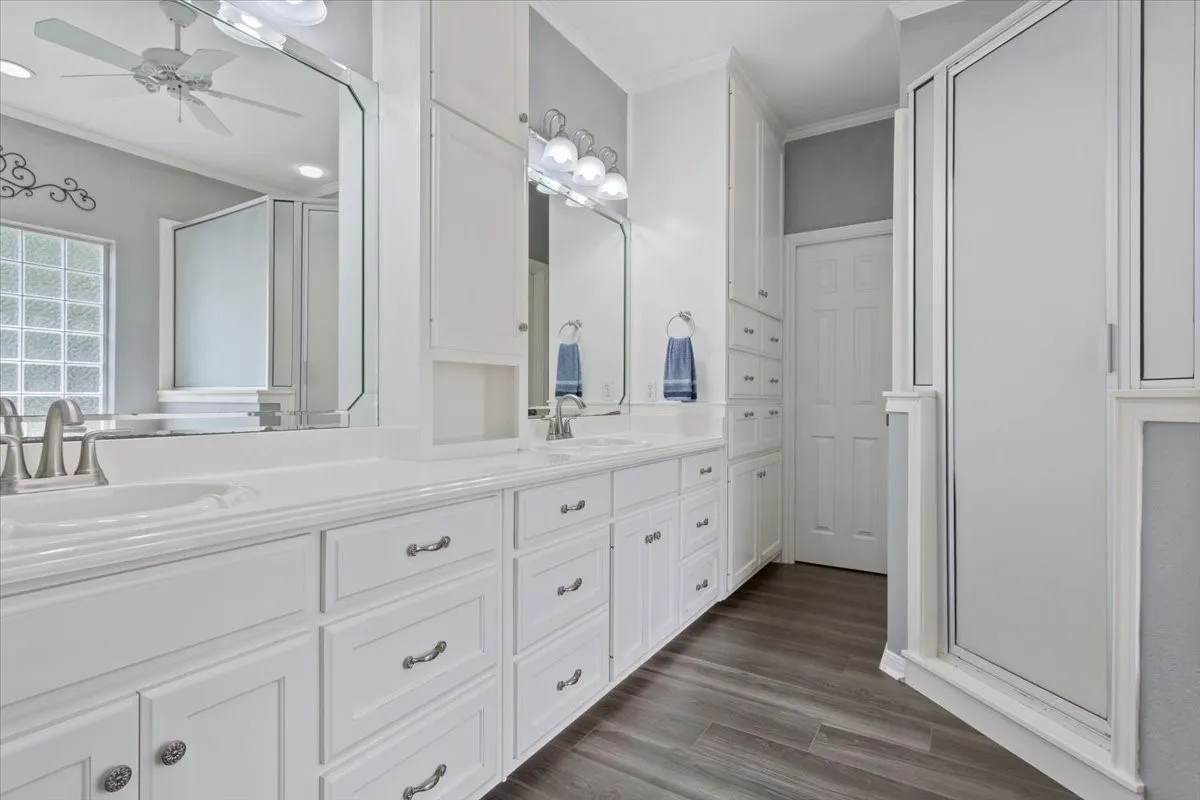 Double vanity with white cabinetry, light countertops, and brushed nickel fixtures