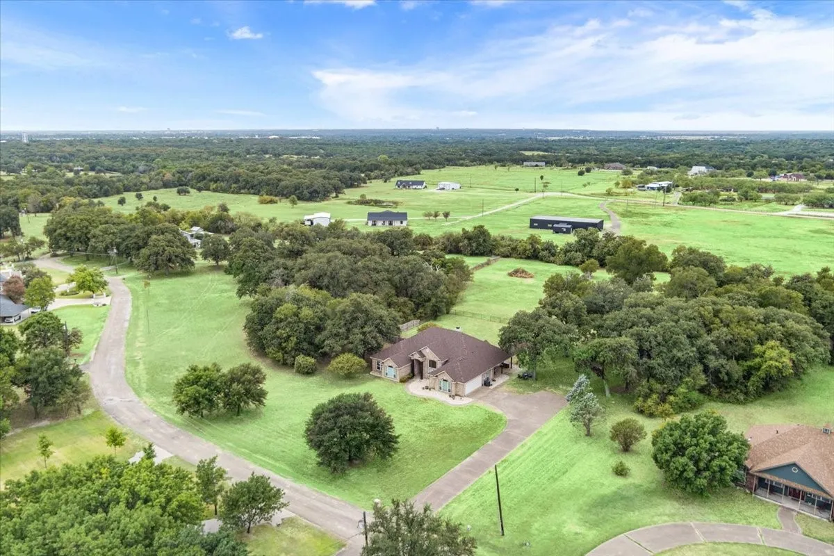 Expansive green spaces with mature trees and paved driveways