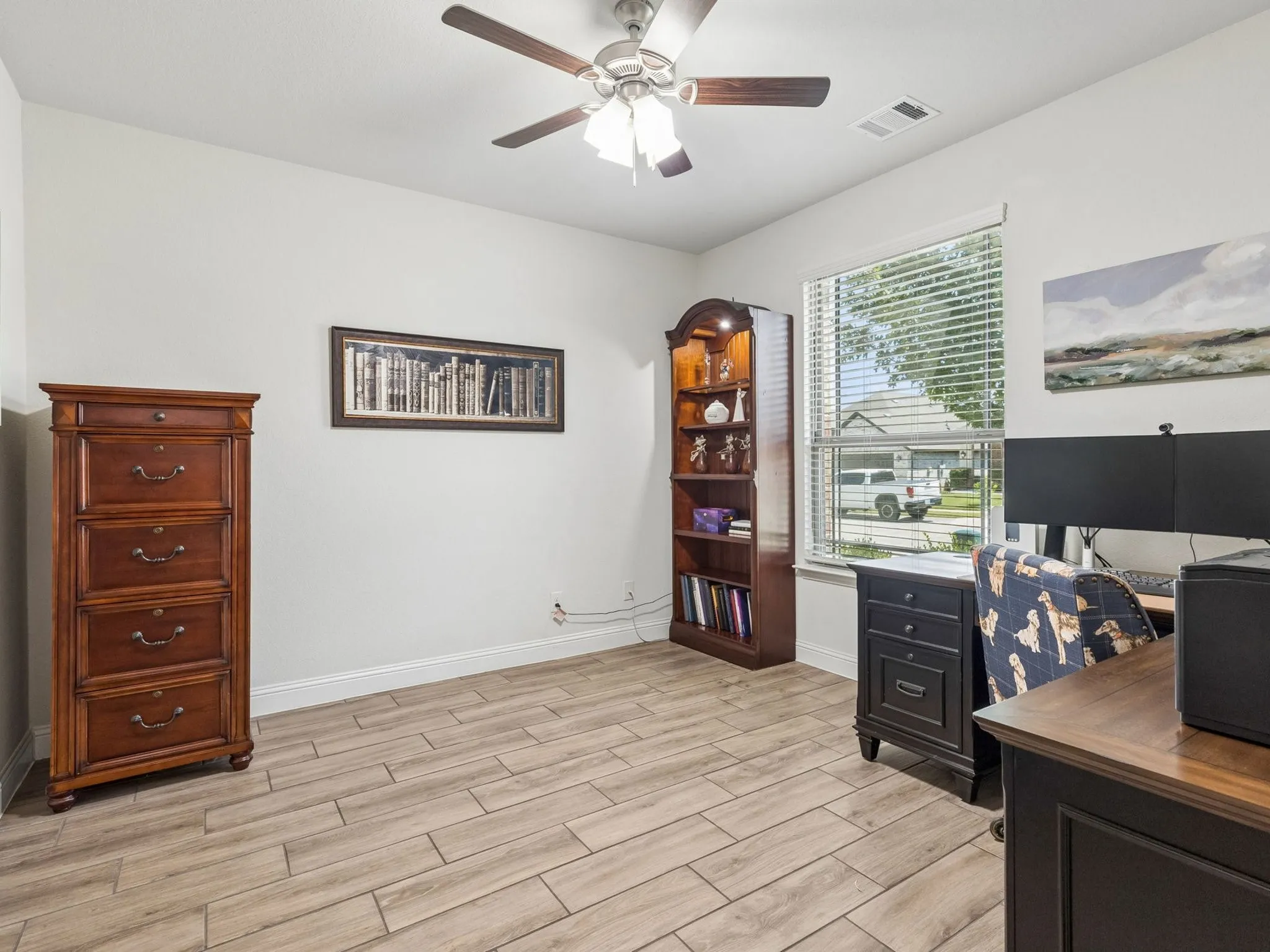 Light wood-finish tile flooring with a ceiling fan light fixture
