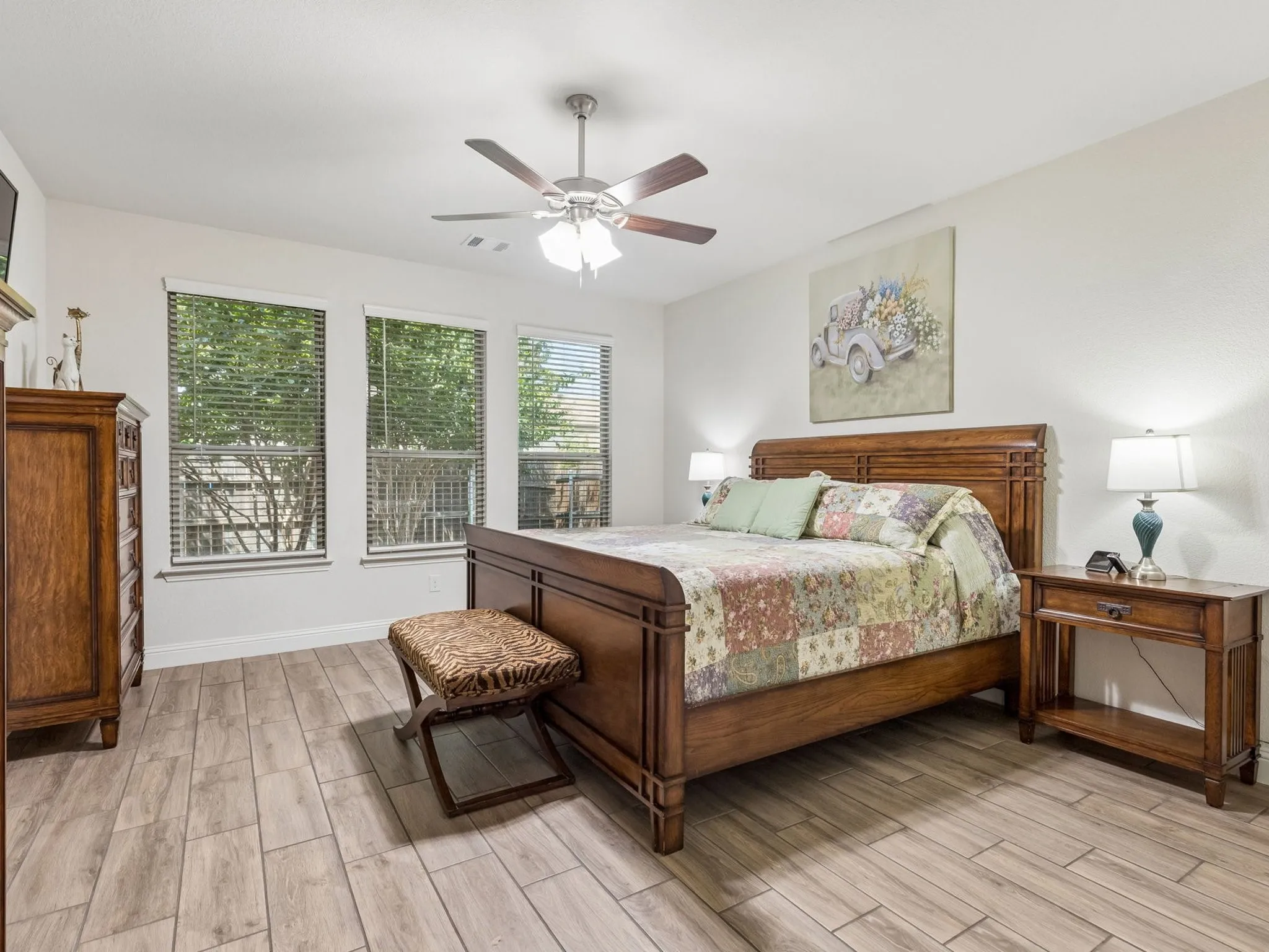 Wood-finish tile flooring with a ceiling fan light fixture
