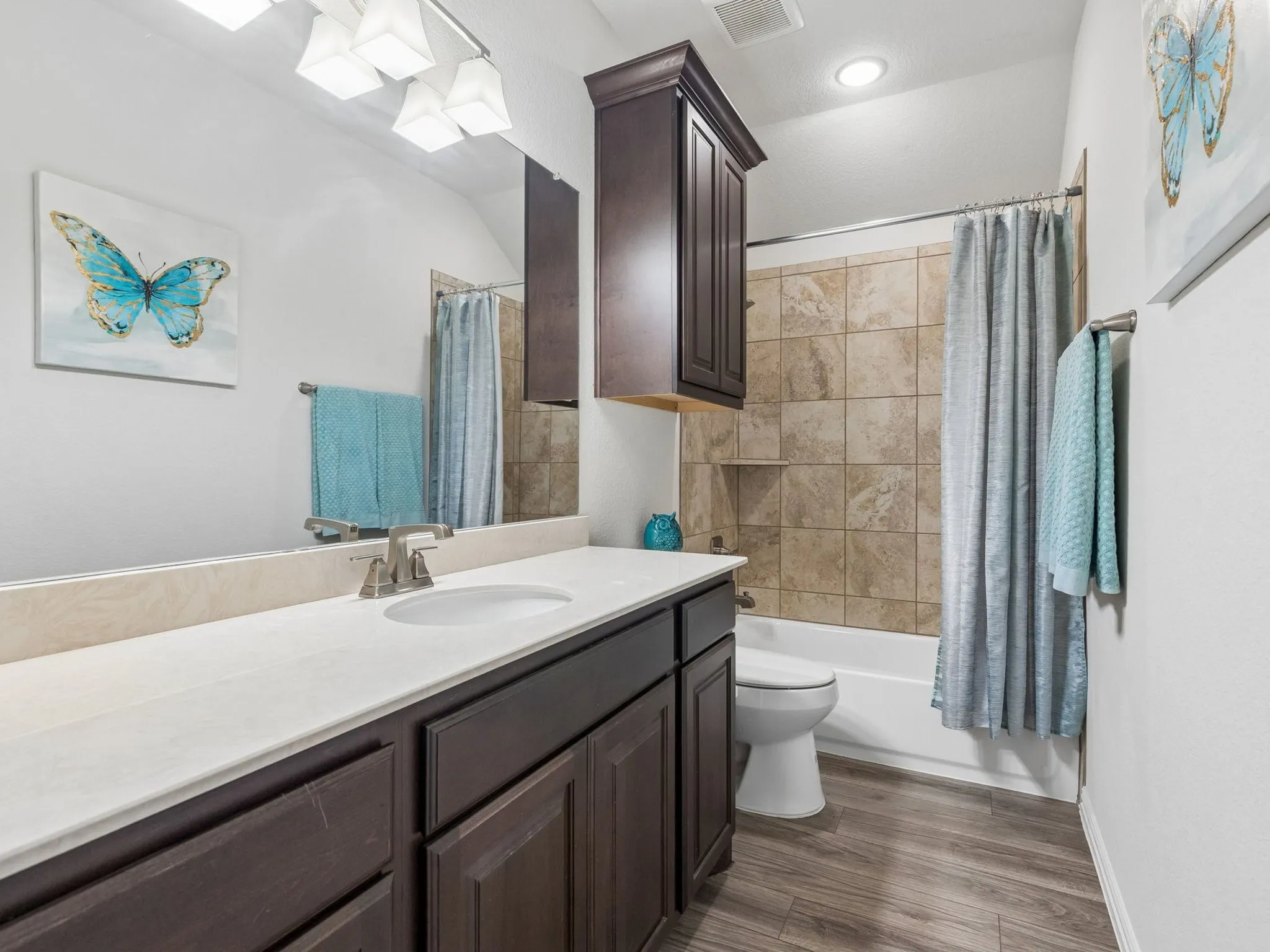Vanity with an integrated sink, dark wood-finish cabinetry, and a large mirror