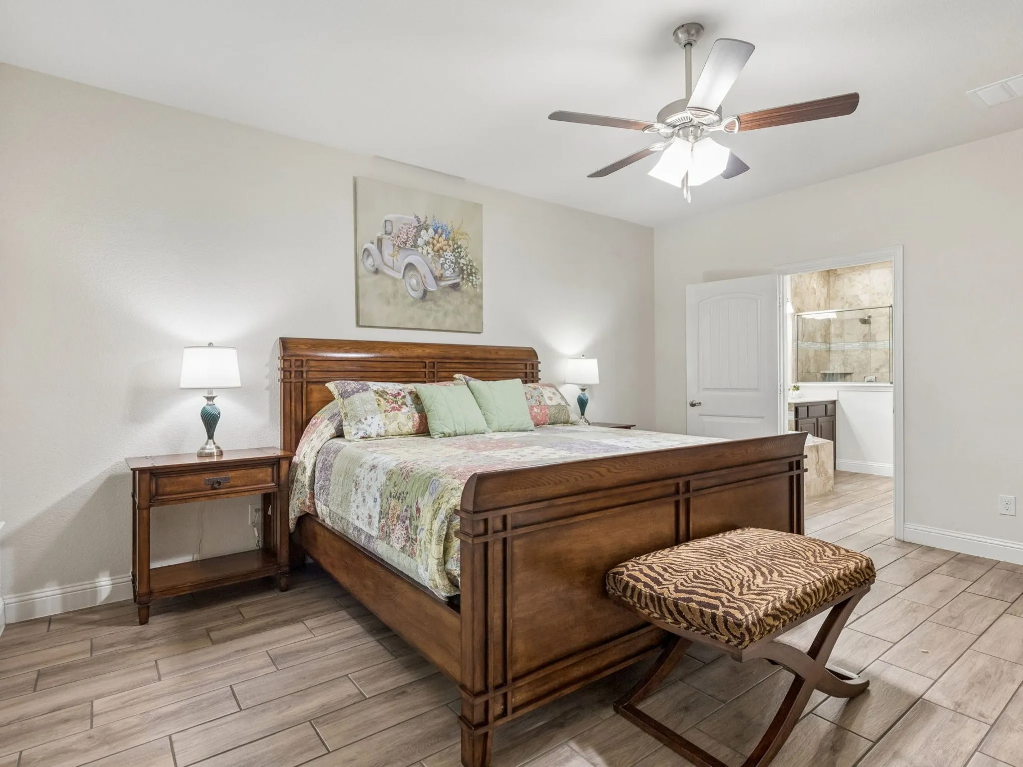 Recessed lighting, ceiling fan, wood-finish tile flooring, white paneled door, and a ensuite bath with a walk-in shower