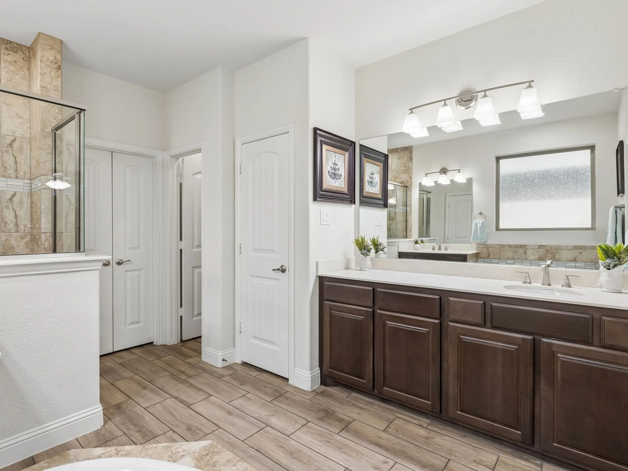 Dual vanity with white countertops, dark wood-finish cabinetry, and brushed nickel fixtures