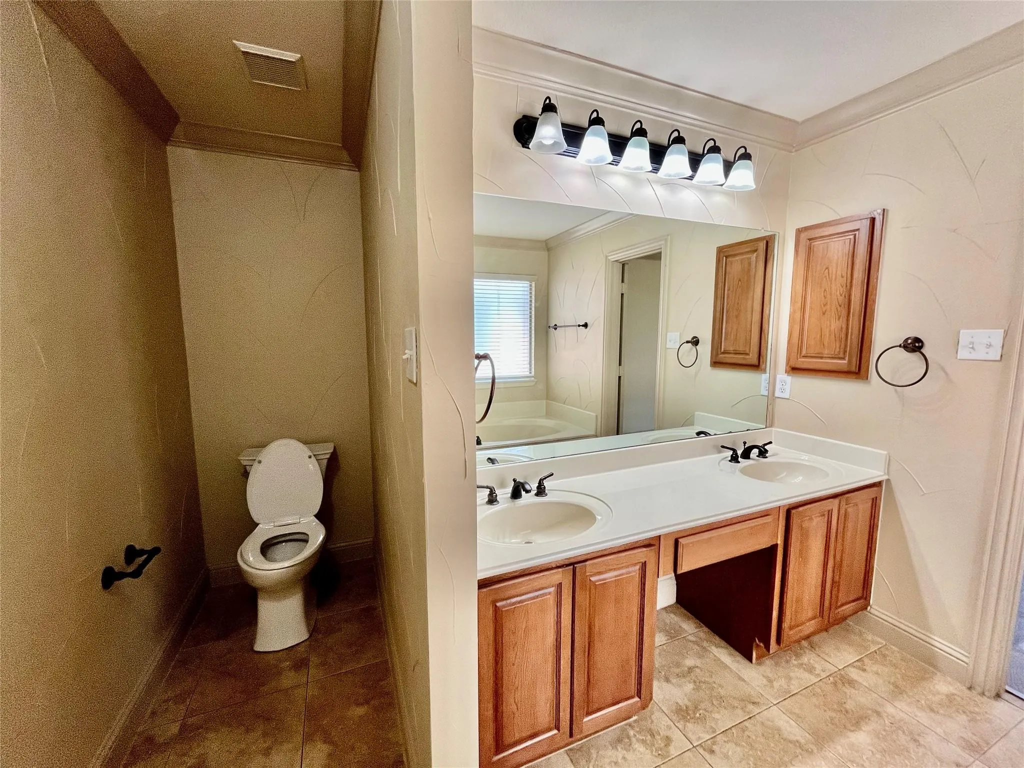 Bathroom with vanity, mirror, toilet, and tile flooring