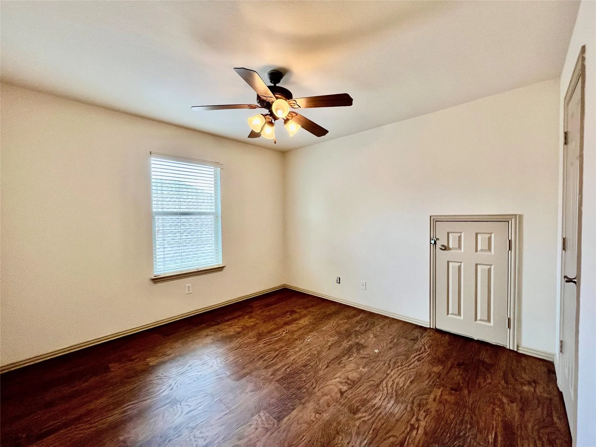 Bedroom with wood flooring, ceiling fan, window, and closet.