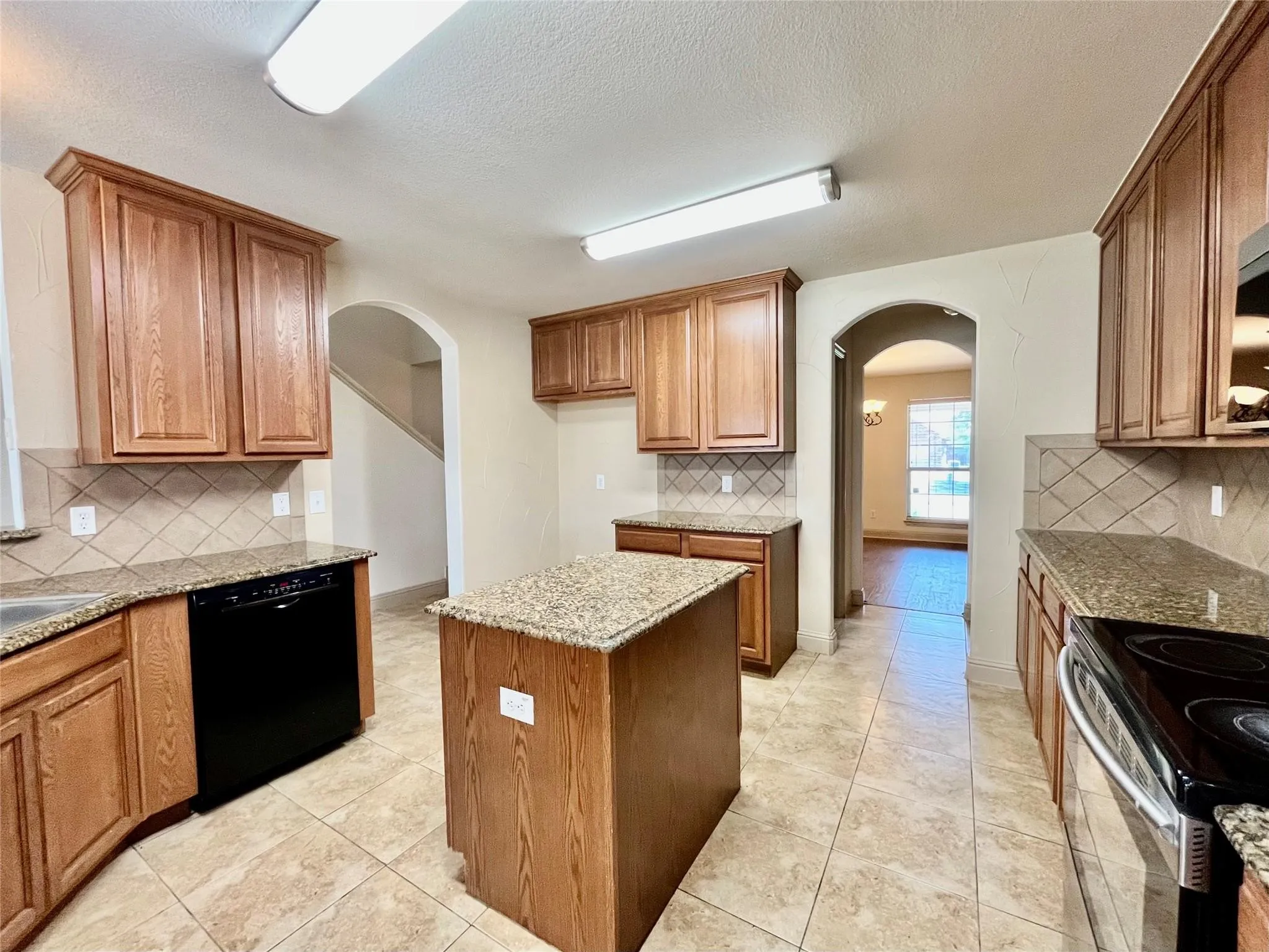 Kitchen with wood cabinets, island, countertops, and appliances