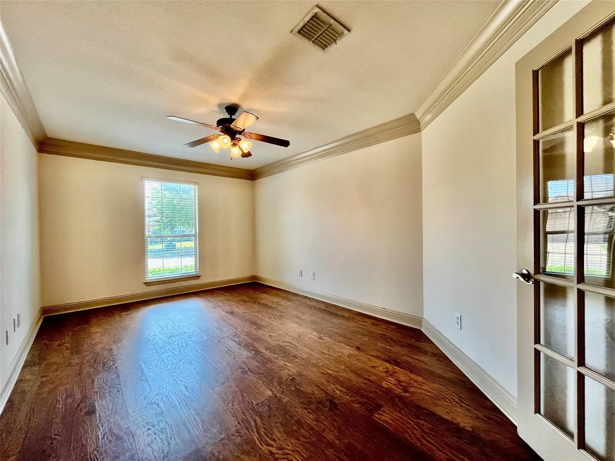 Living room with wood flooring, ceiling fan, and windows