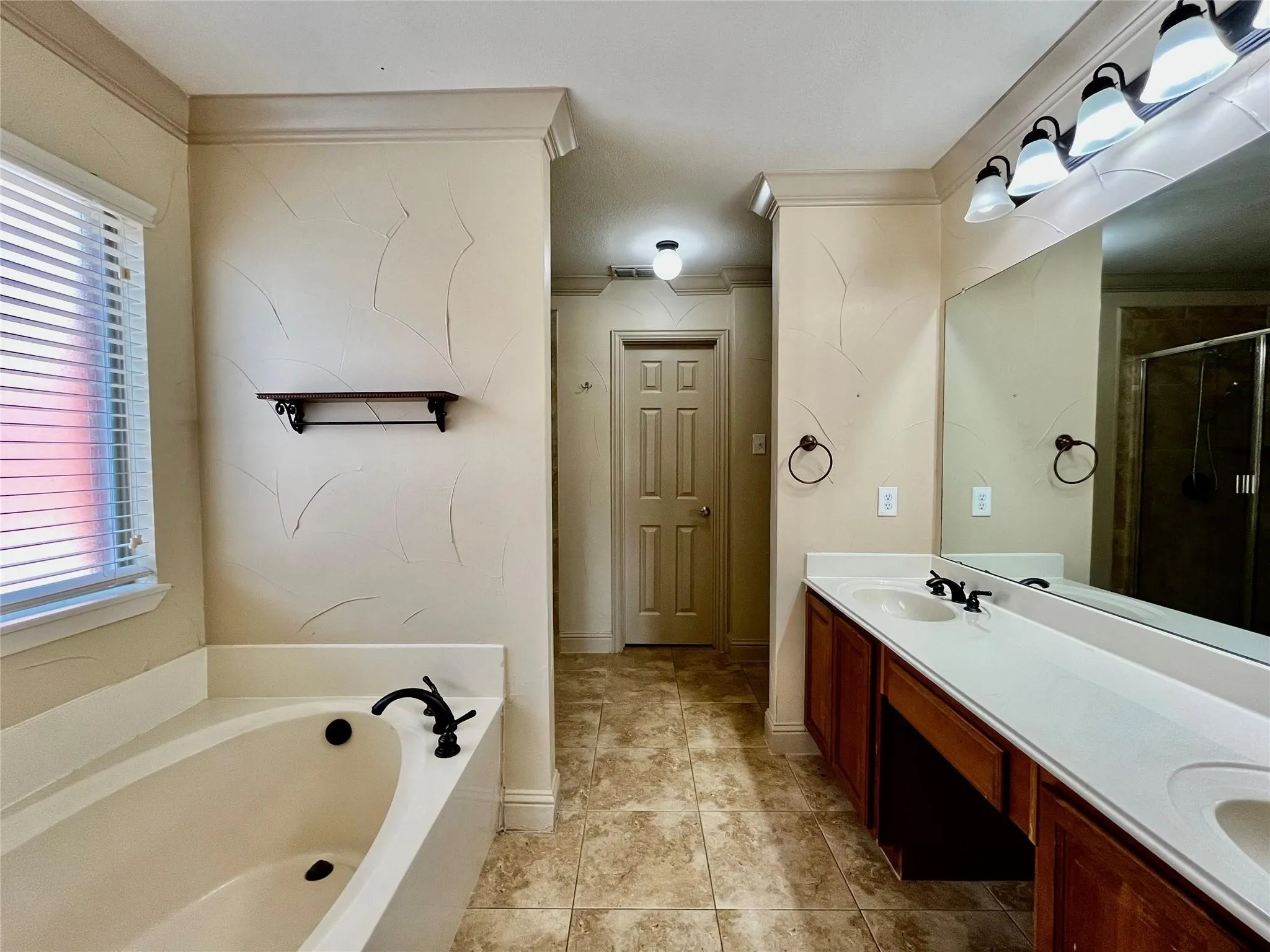 Bathroom with tub, walk-in shower, vanity, and tile flooring